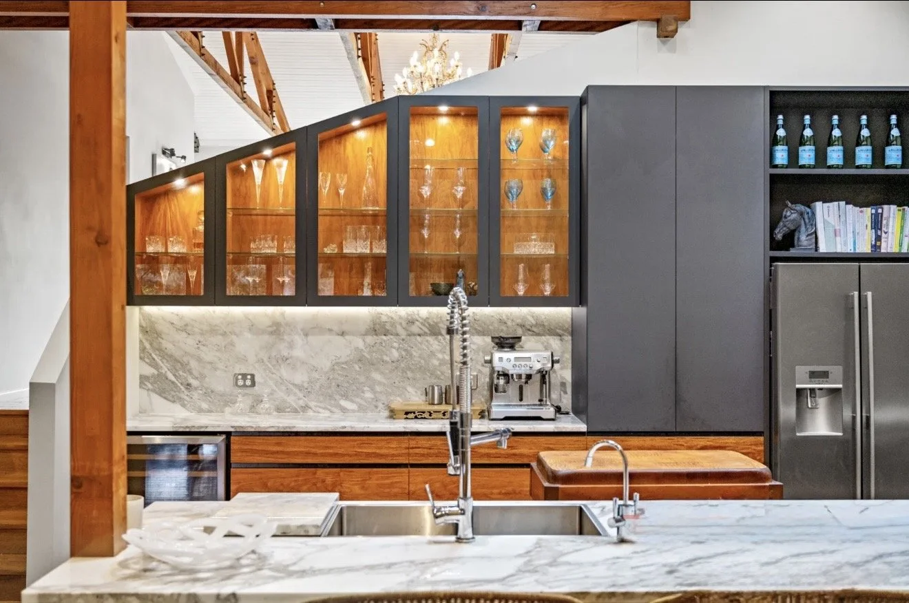Modern kitchen with marble countertops, wooden and dark gray cabinets