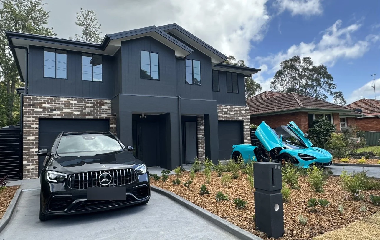 Modern two-story house in front of a suburban neighborhood.