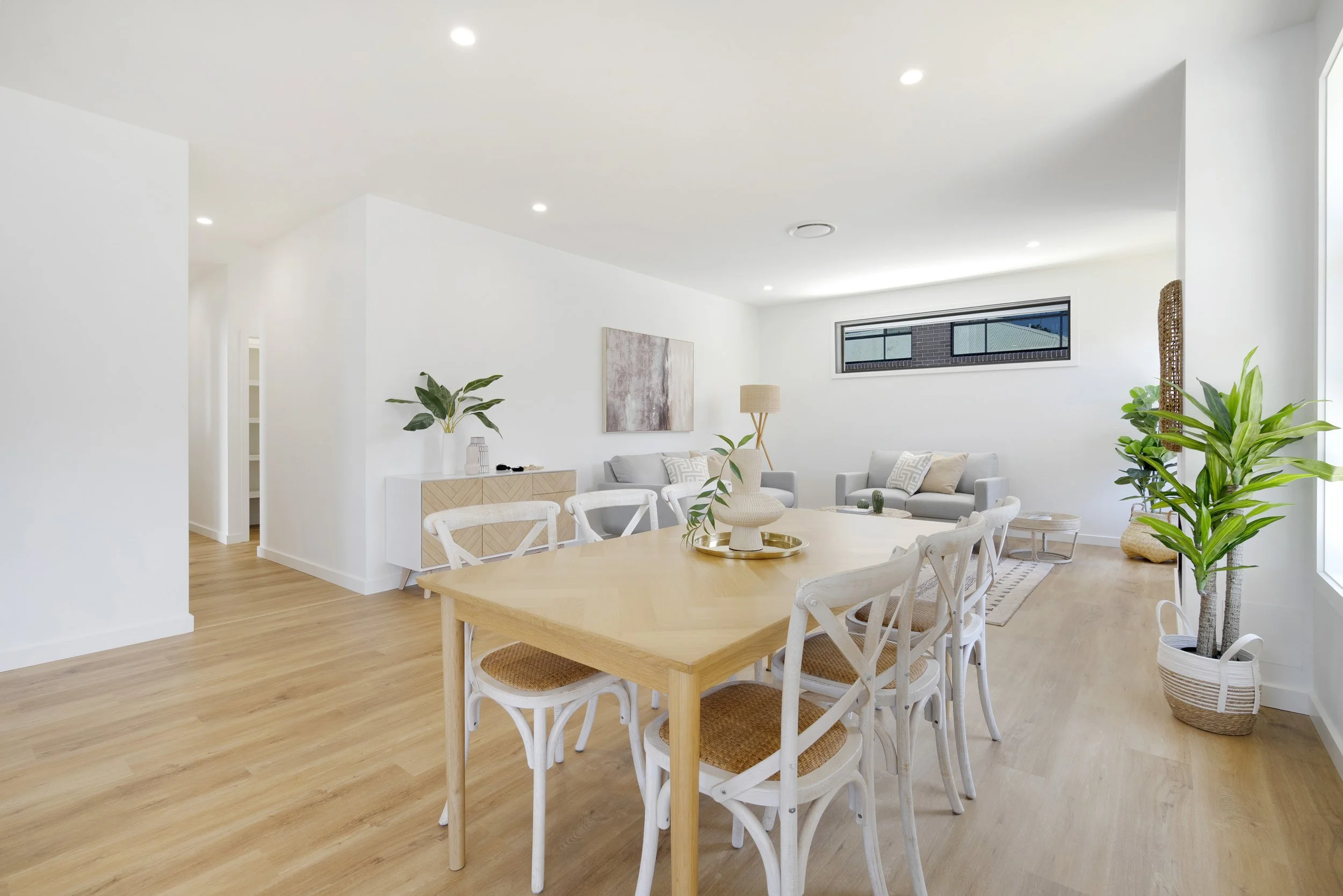Bright living and dining room with white walls, wooden flooring, a large window - in Hunter's Valley custom home built by SWW BUILDING GROUP