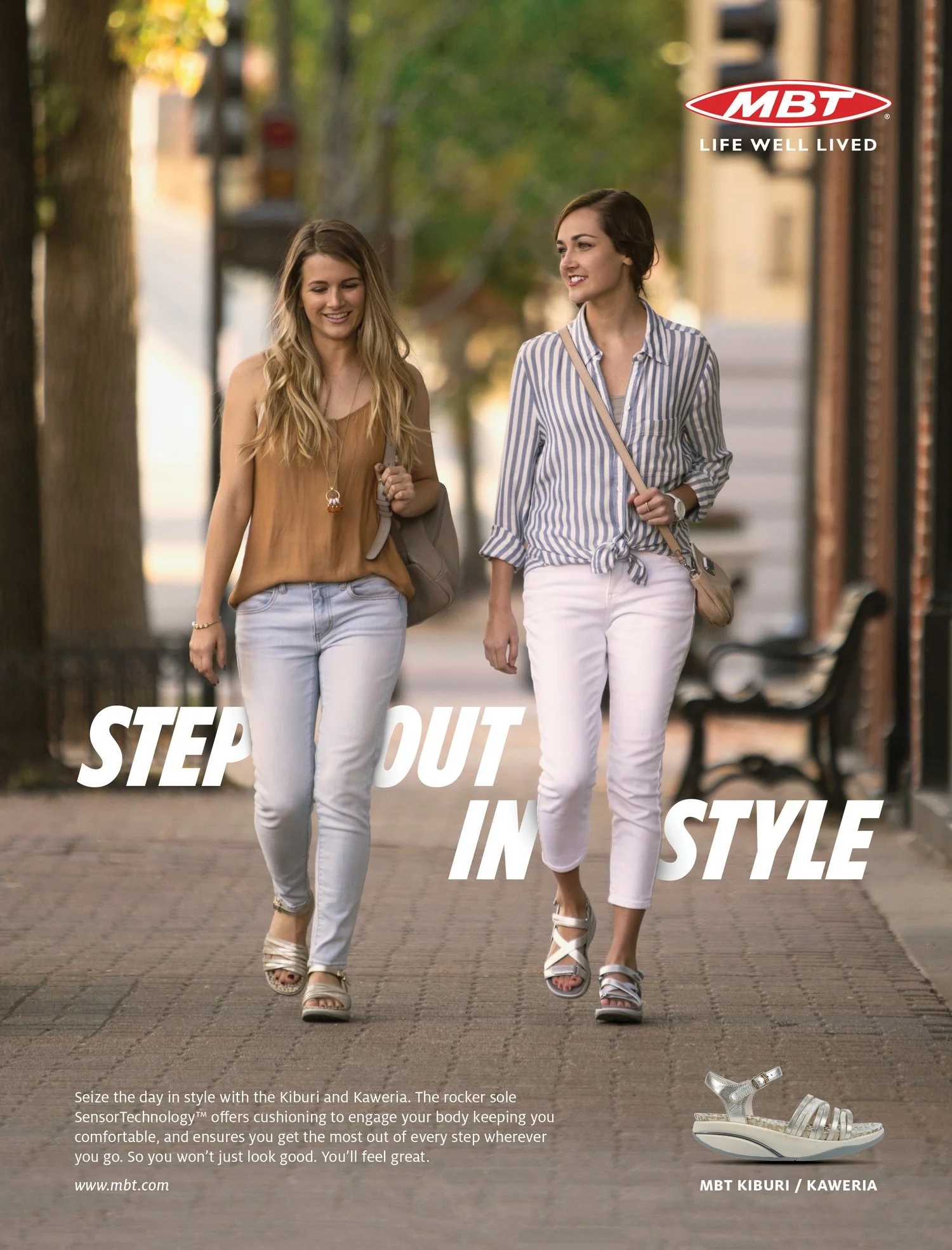 Two women are walking outdoors on a city sidewalk at sunset, smiling and dressed in casual summer clothing. The scene promotes MBT shoes, emphasizing comfort and style with the tagline 'Step Out in Style.' A single sandal is shown at the bottom right