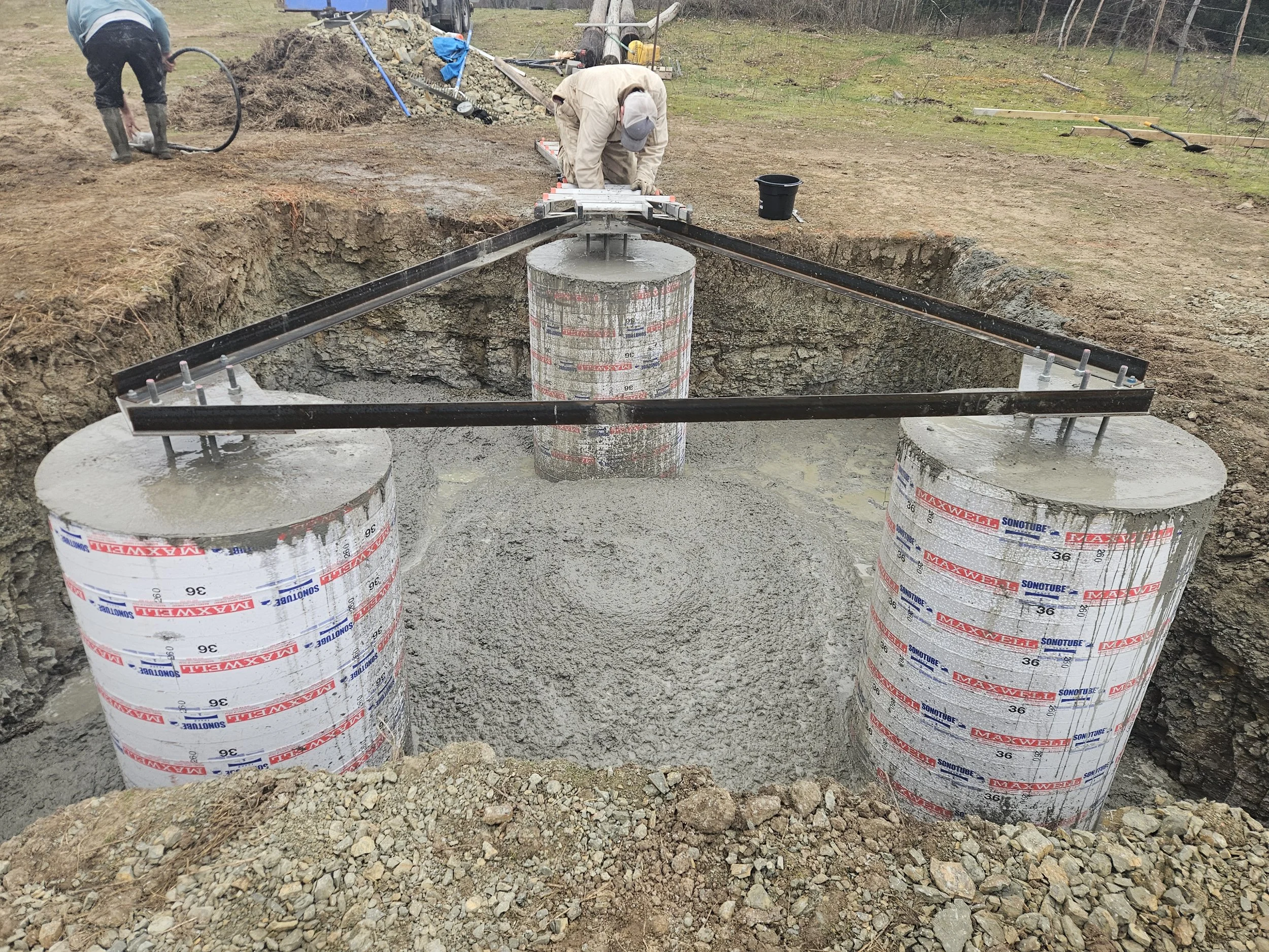 Pouring concrete piers using Sonotube forms for a communications tower foundation. Site preparation, foundation construction, and civil support services for new tower infrastructure projects by Green Country Tower Service.