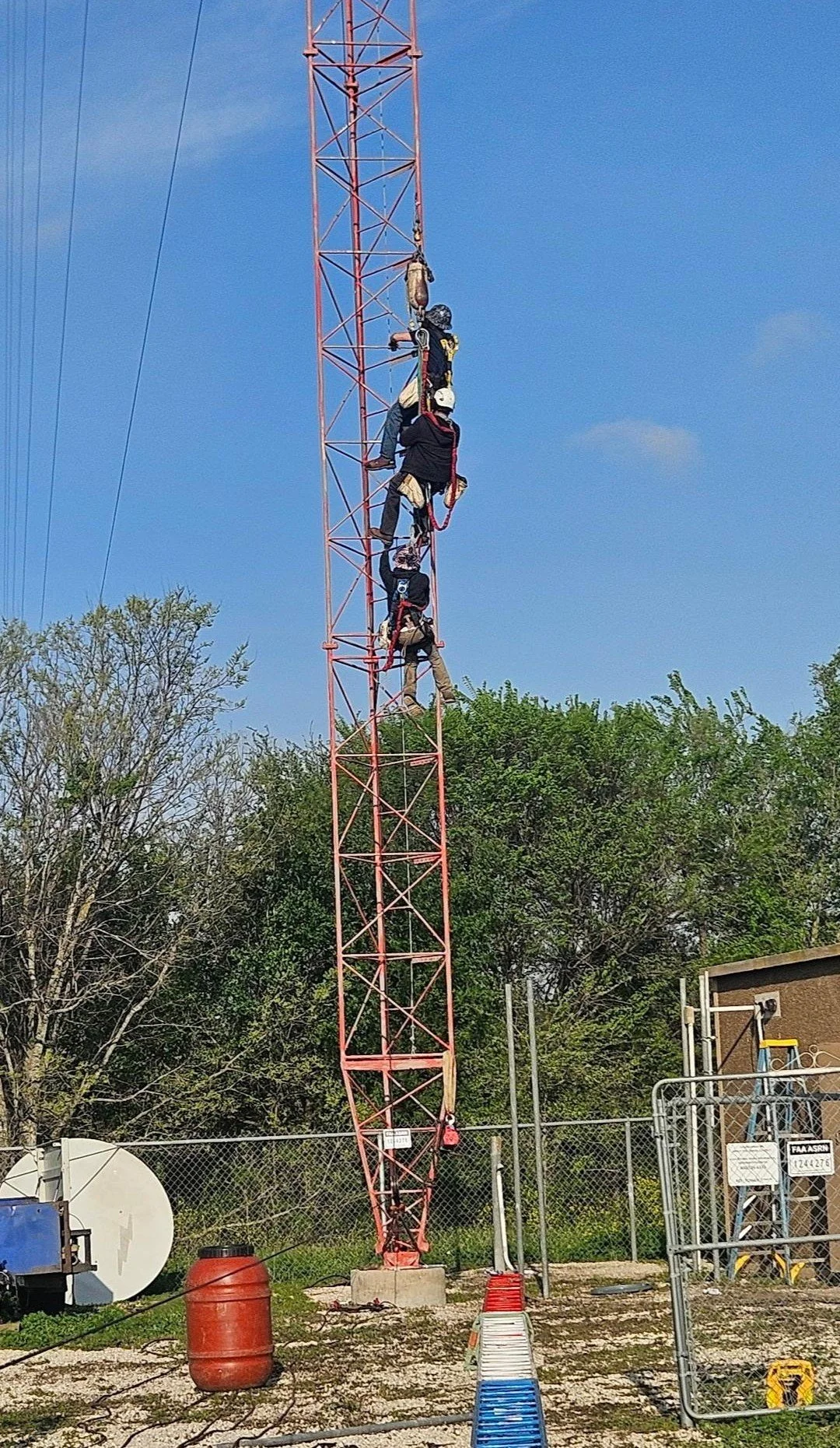 Tower crew riding the line during a high-elevation broadcast tower construction project. Specialized tower rigging, antenna installation, and communications infrastructure work by Green Country Tower Service.