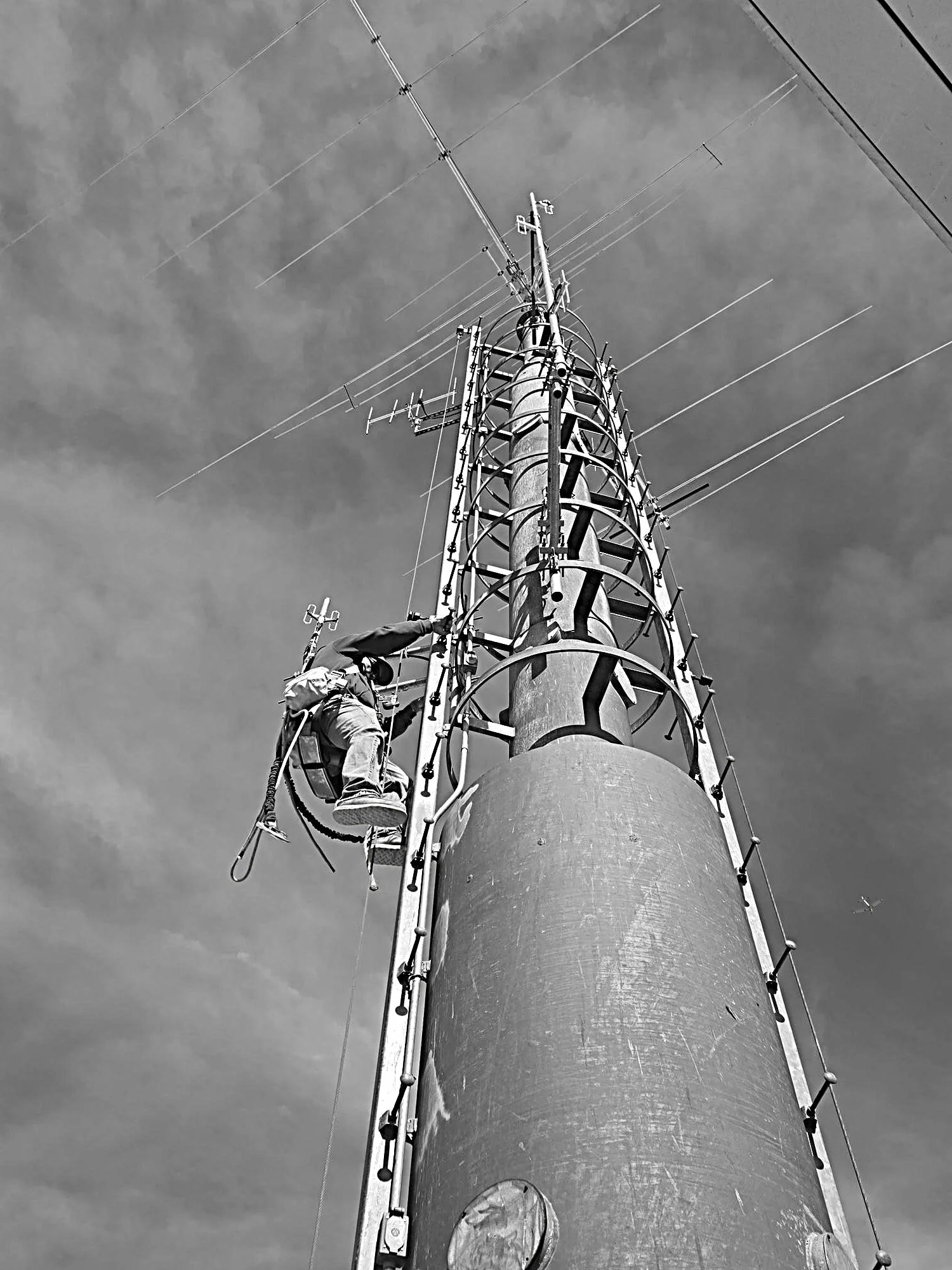 Tower climber performing communications tower maintenance and antenna work on a broadcast tower for Green Country Tower Service.