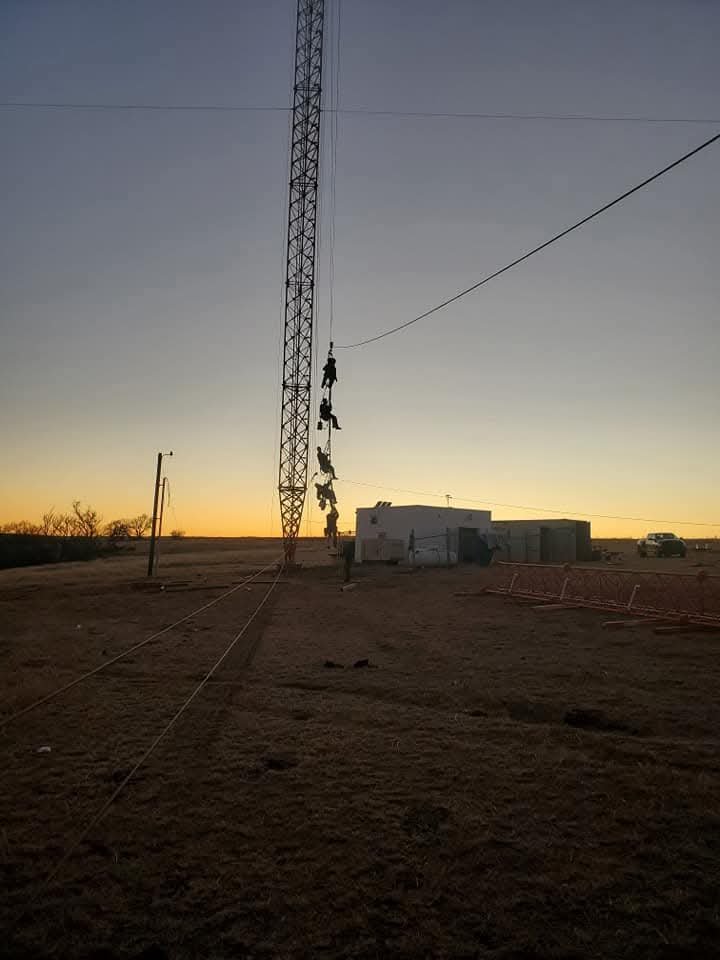 Tower climber descending after broadcast tower stacking operations in El Reno, Oklahoma. Green Country Tower Service provides tower construction, structural rigging, inspections, and communications infrastructure support nationwide.