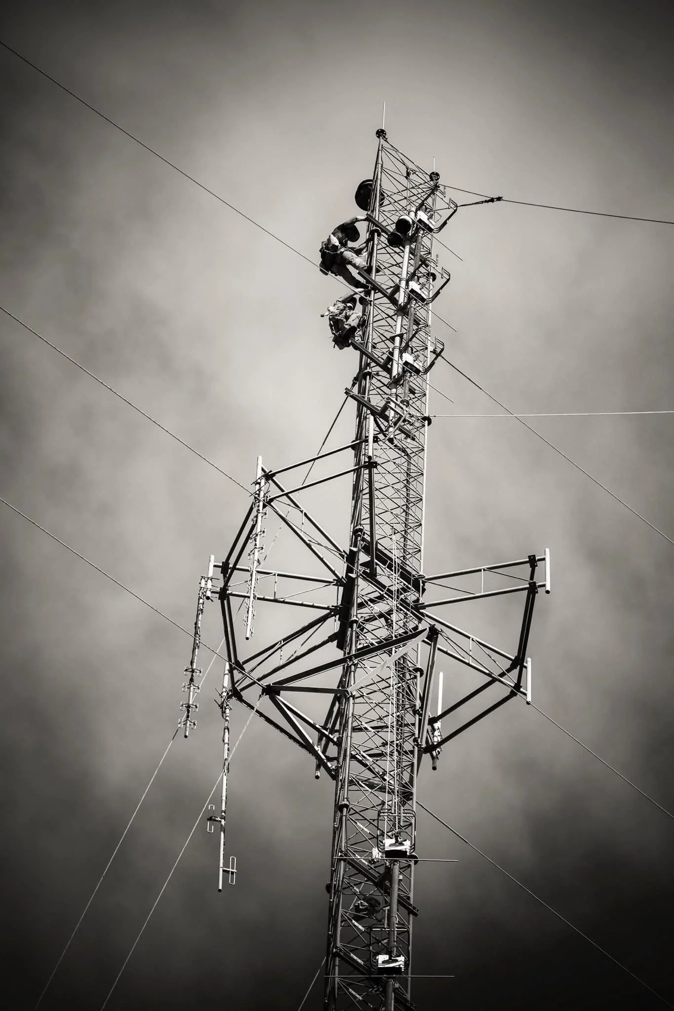 Tower technicians climbing a communications tower performing inspection and maintenance services on broadcast infrastructure.