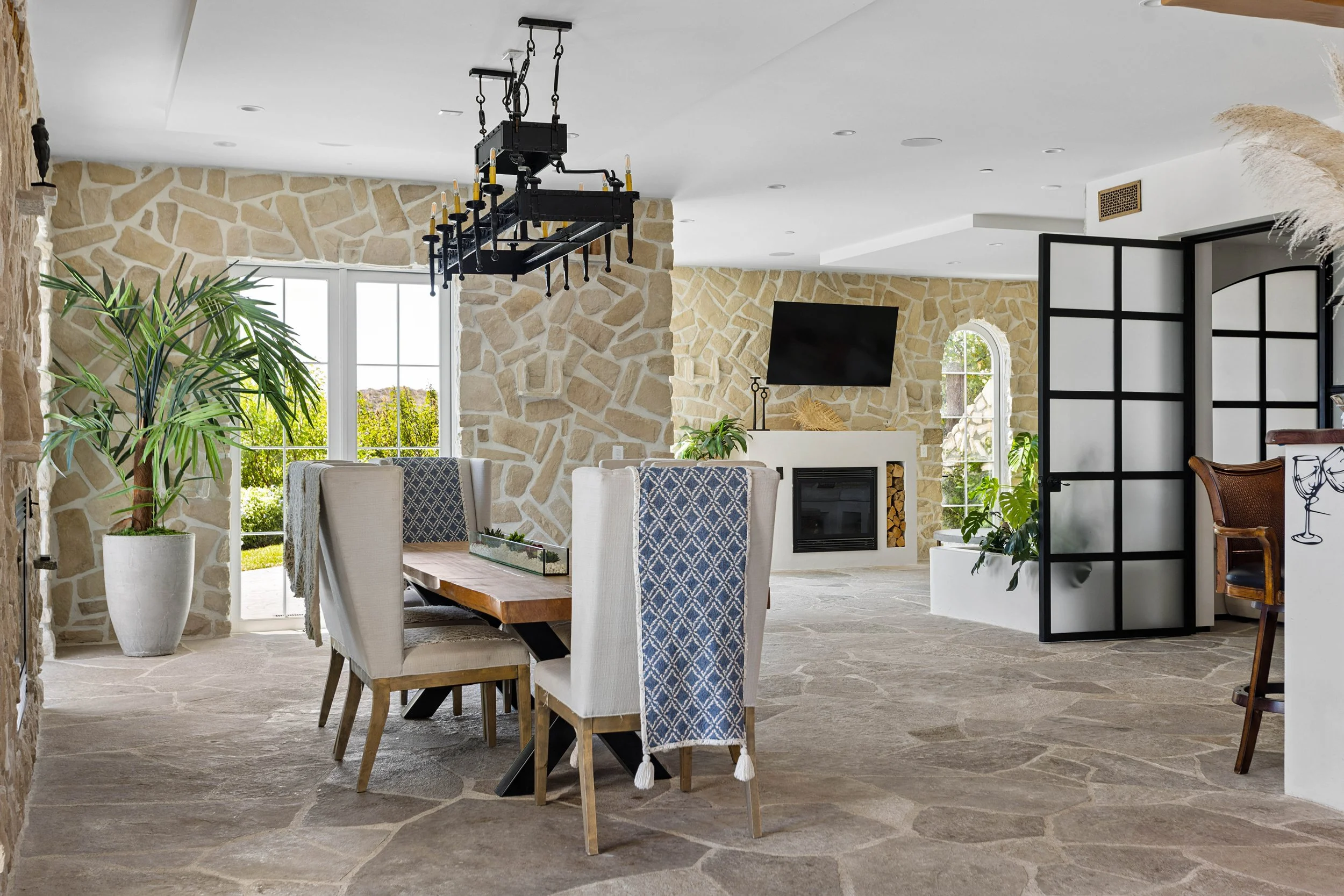 malibu-mediterranean-villa-great-room-stone-steel-doors.jpg