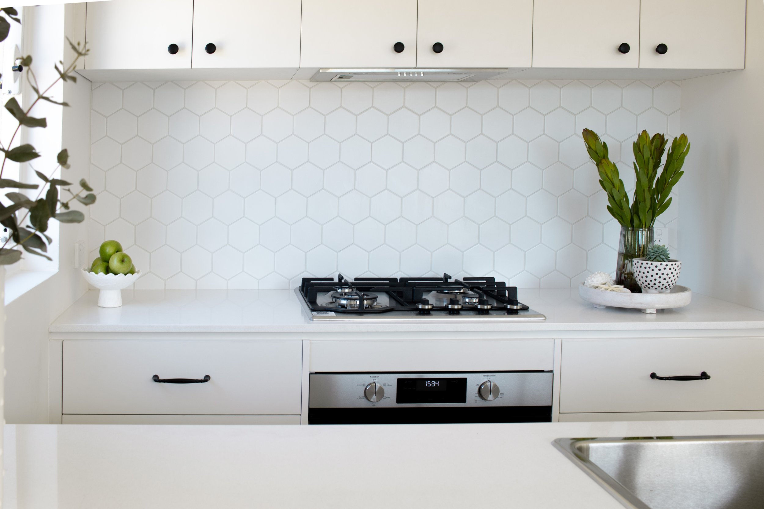 White renovated kitchen with white and green styling elements