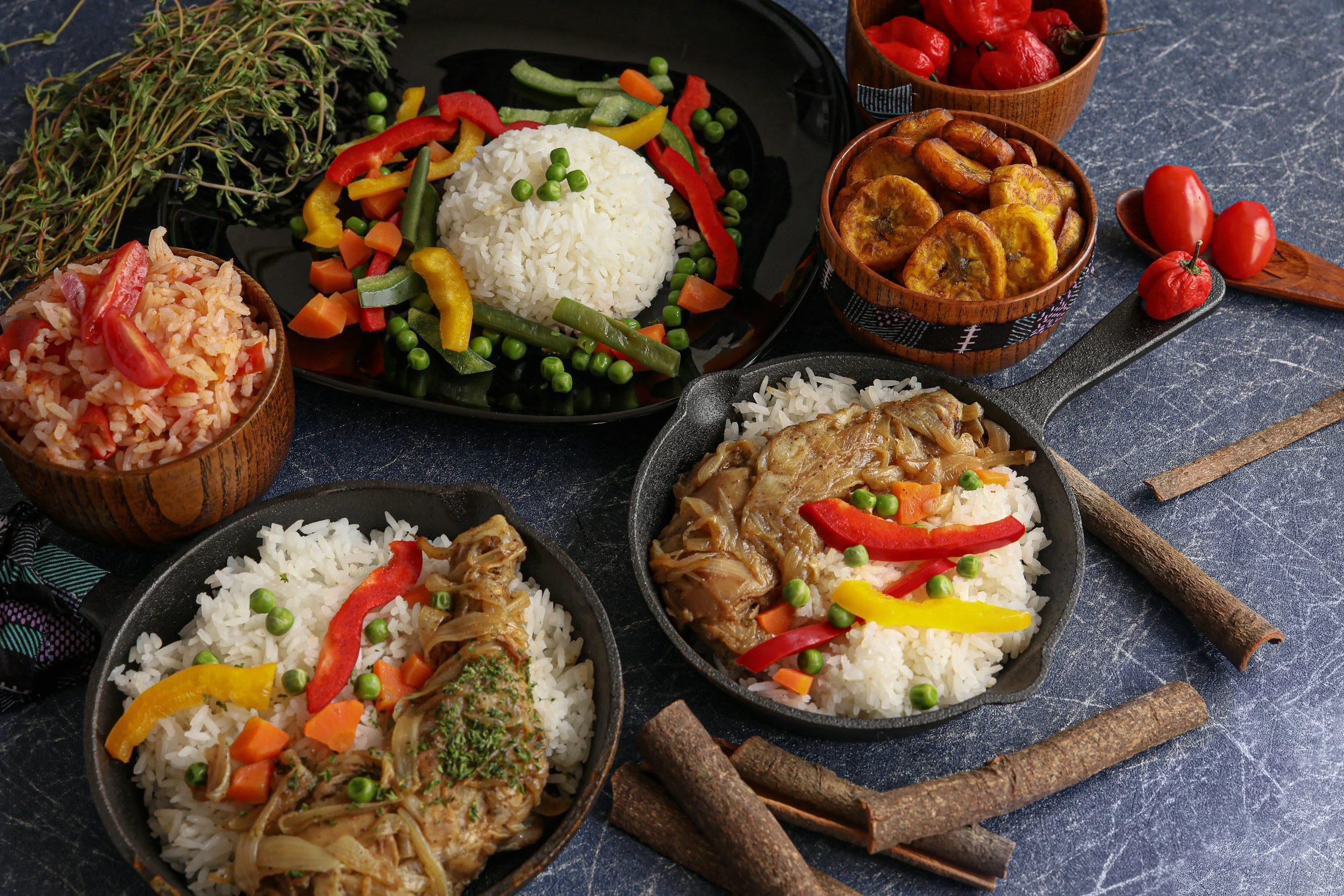 Photo of African food including plantains, rice, chicken and various vegetables