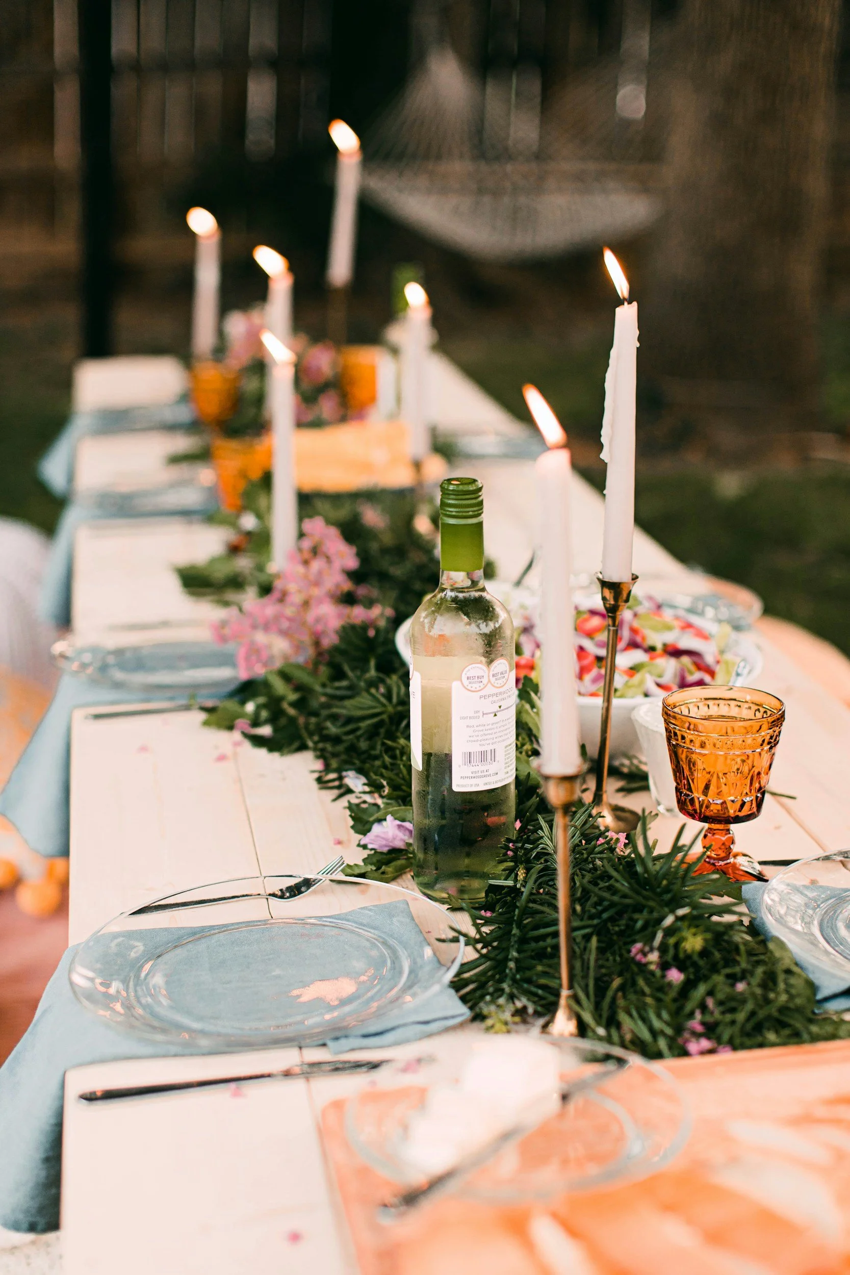 Photo of a beautiful table outdoors set with candles and wine