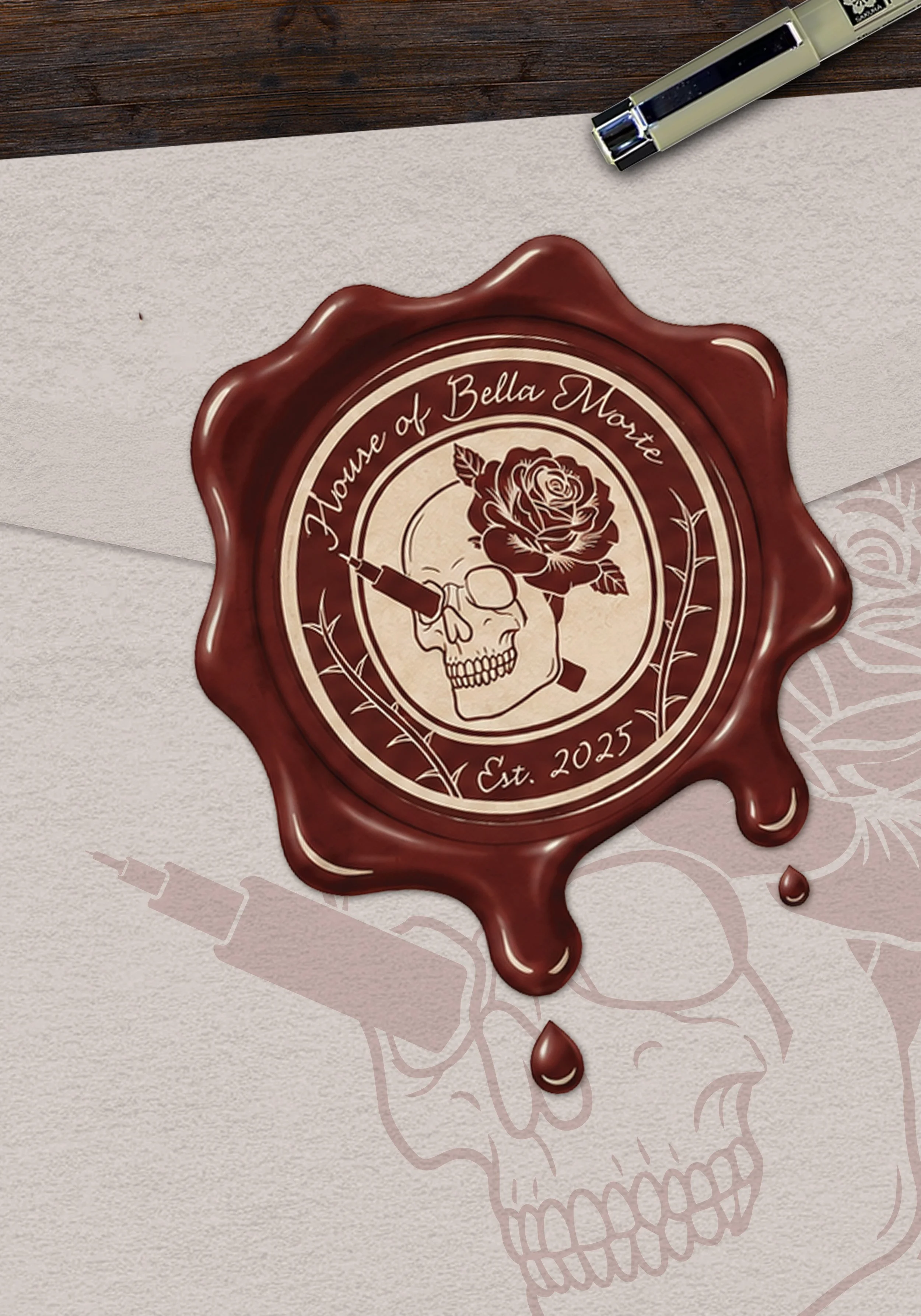 A wax seal sticker with the text 'House of Bella Monet,' a rose, and a skull, surrounded by a decorative border. The seal is placed on a piece of white paper, with a dark wooden surface and a stapler nearby.