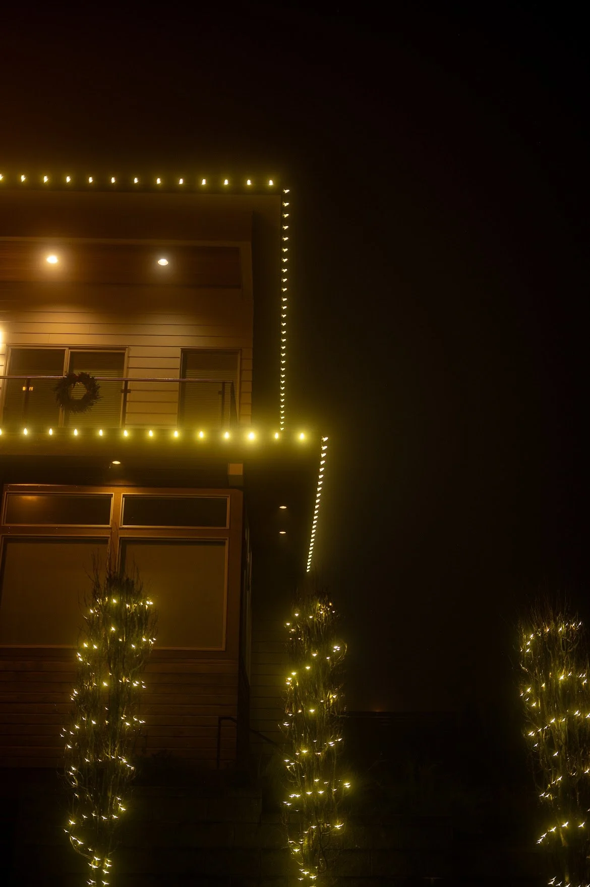 C9 bulbs along roofline and string lighting around trees