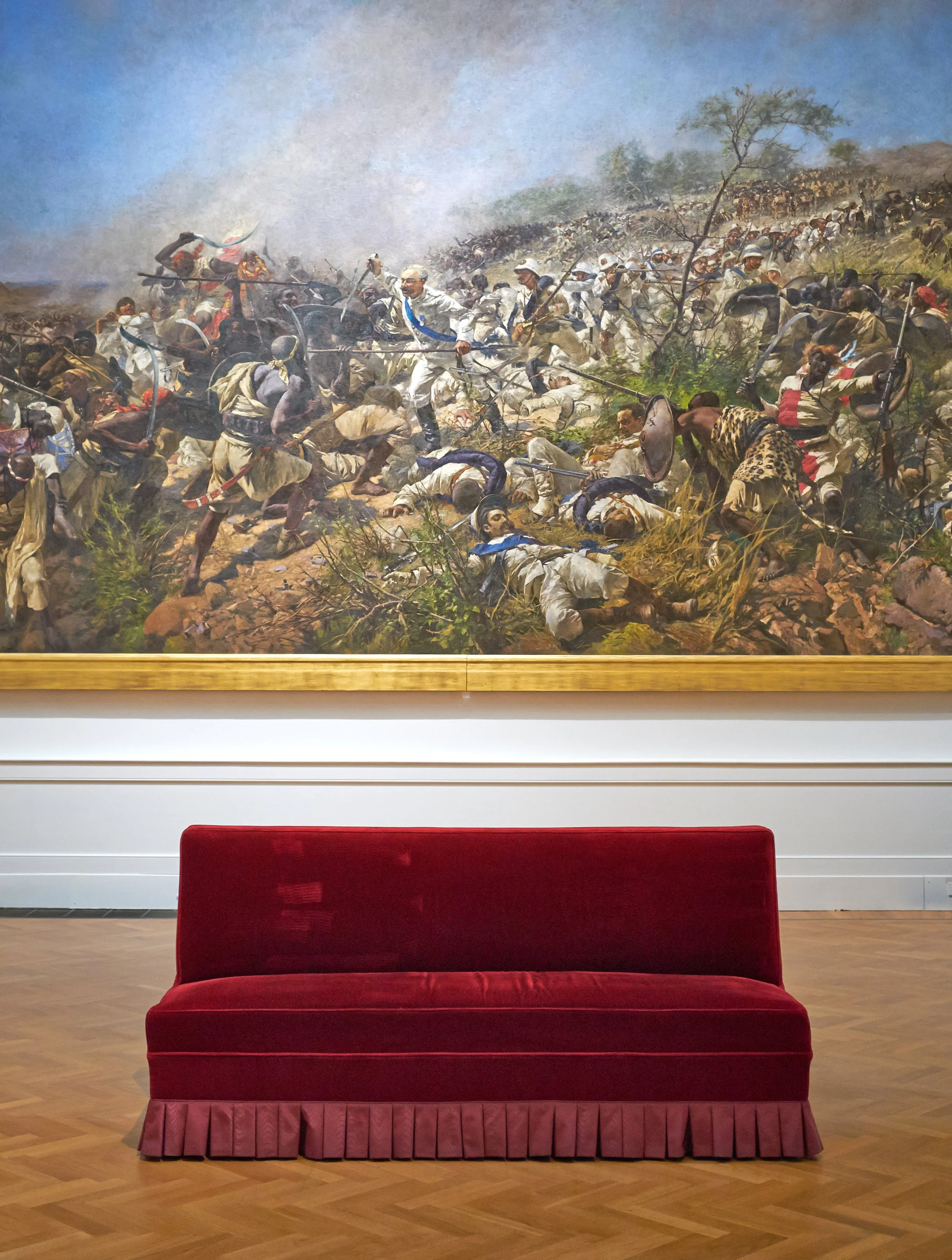 Serene red sofa and gory battle painting