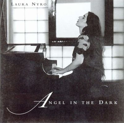 A woman with long dark hair sitting at a piano, looking upward, in front of a large window with multiple panes, with text that reads 'Laura Nyro' and 'Angel in the Dark'.