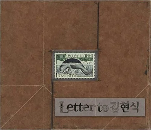 A postage stamp and a paper label with the text 'Letter to 김현식' on a tiled surface.