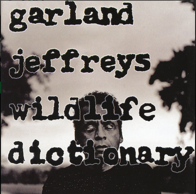 Black and white album cover featuring a man's face with the words 'Garland Jeffreys Wildlife Dictionary' written in large, black, distressed font overlaying the image.