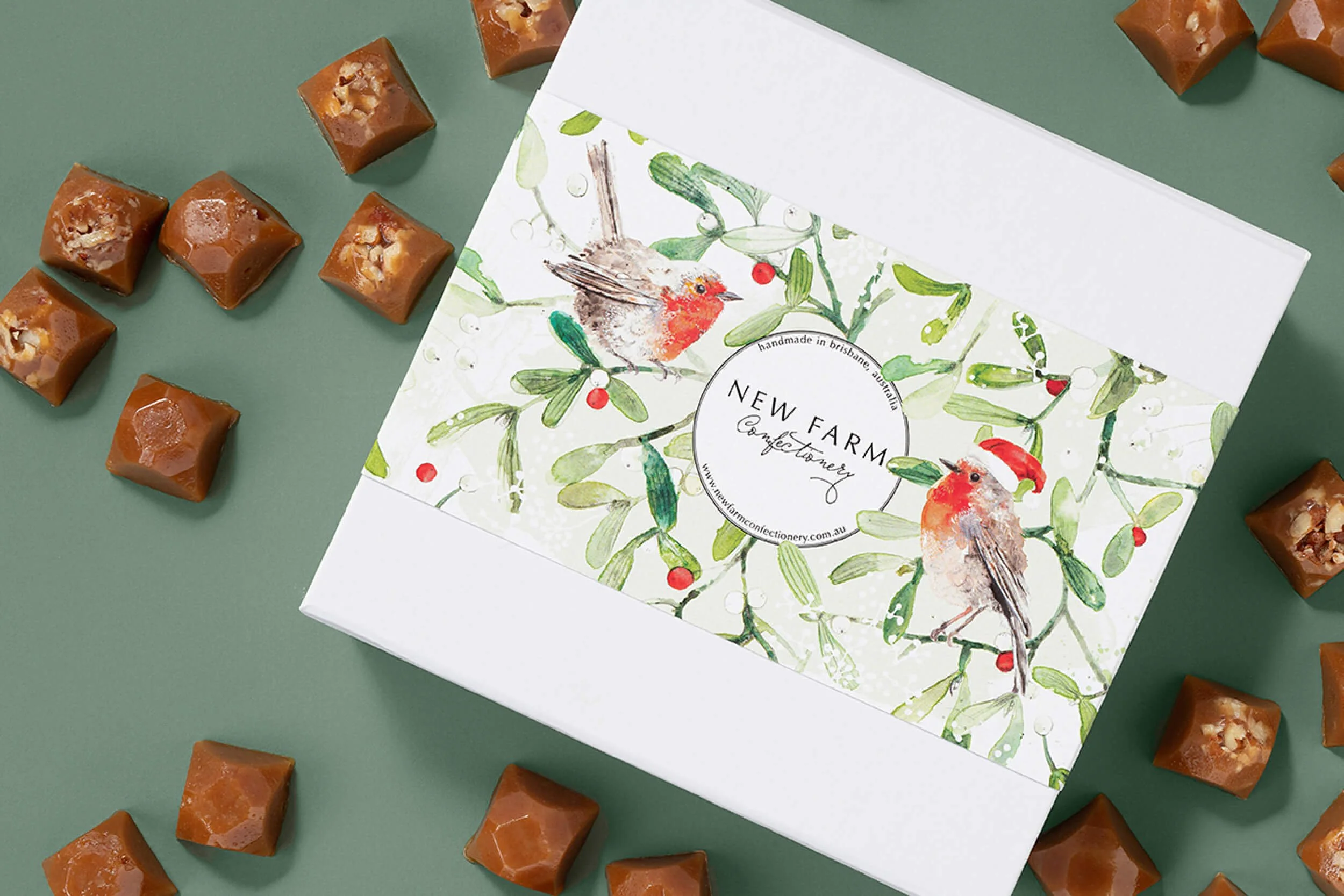 Hand-painted watercolour red robin and mistletoe packaging illustration created for New Farm Confectionery Christmas seasonal gift box campaign.