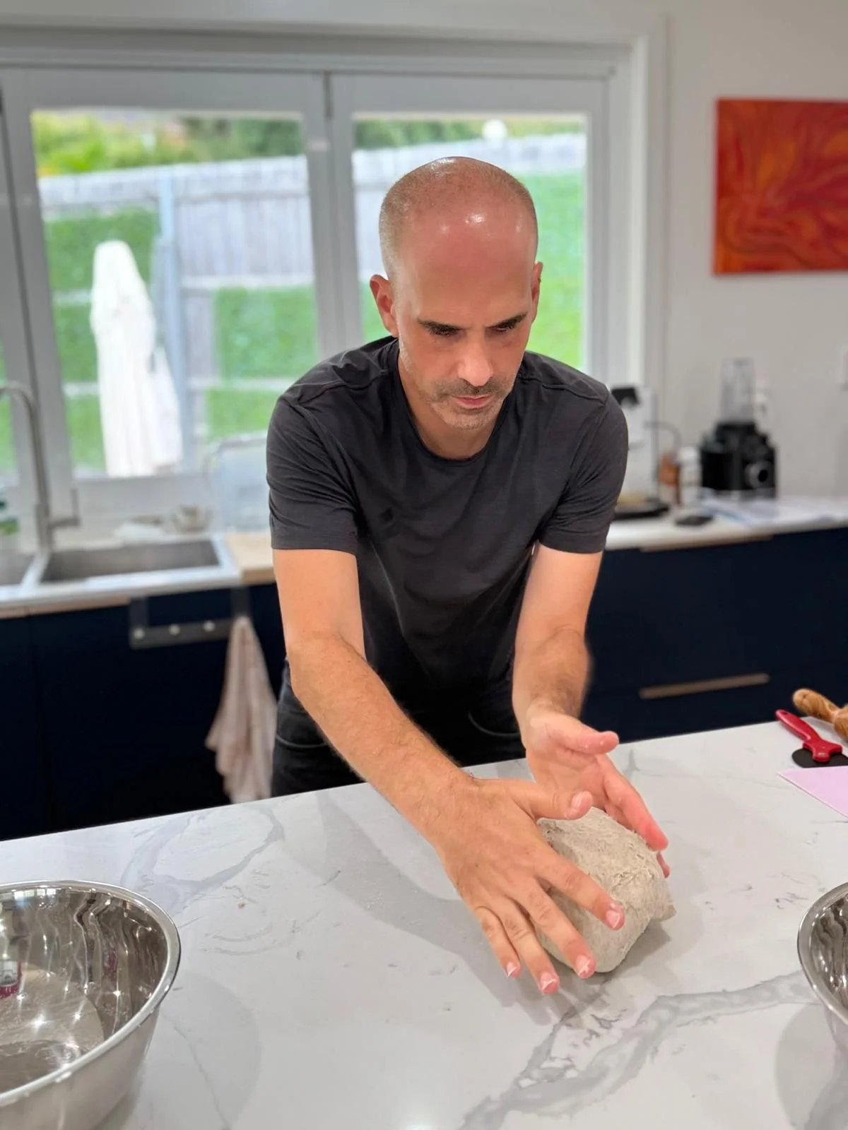 Professional sourdough baking instructor teaching dough shaping techniques in Australia