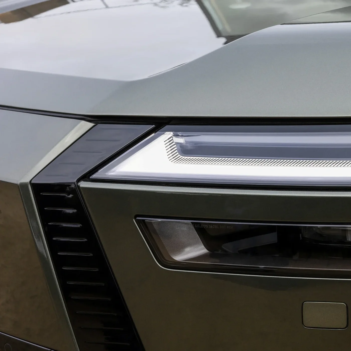 Close-up of the front right corner of a silver modern car, showing the headlight and part of the front grille.