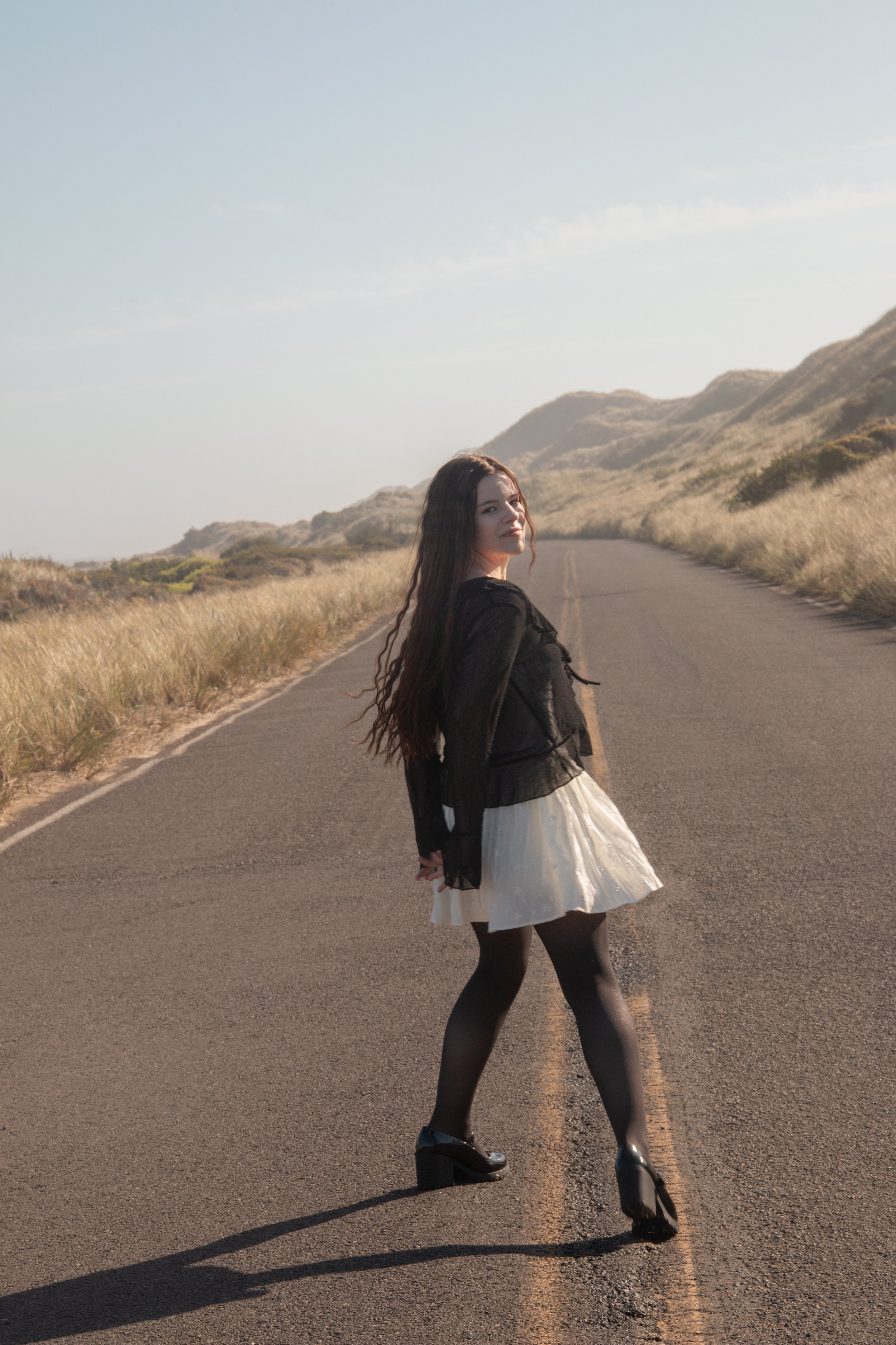 Girl in road in white dress and black top
