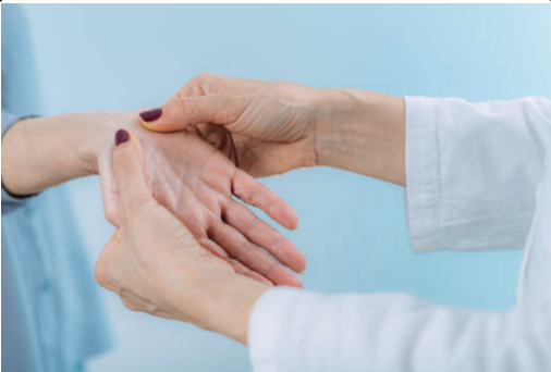 A person holding another person's hand in a supportive gesture, with a blue background.