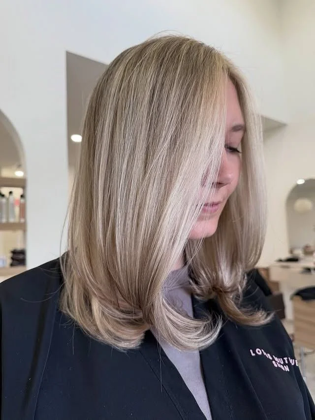 Dimensional blonde highlights on a mid-length blowout, styled at Lotus Boutique Salon in Tomball, TX.