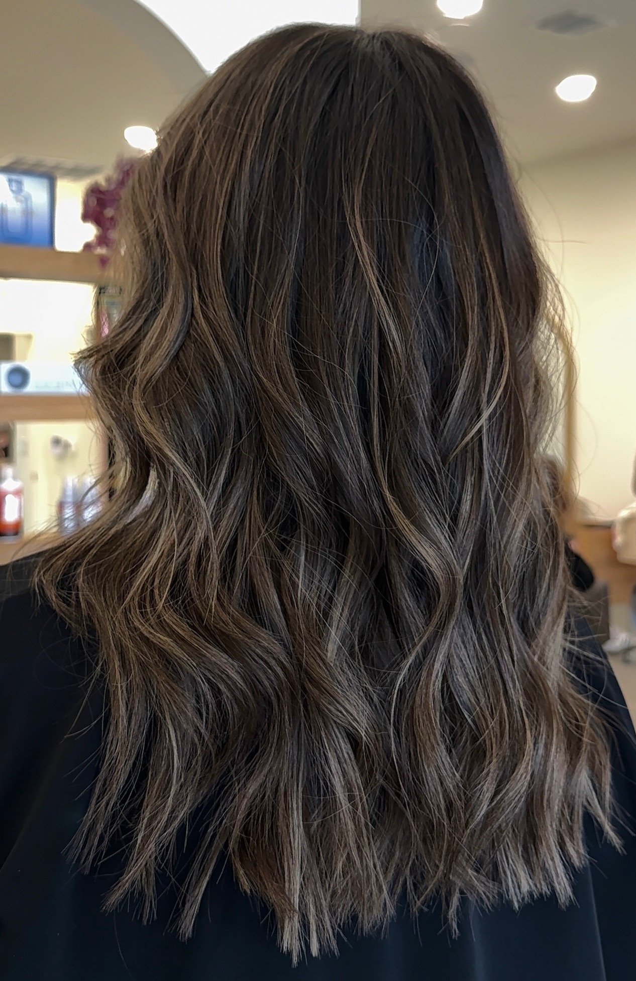 Hair styled with loose waves in a salon setting.