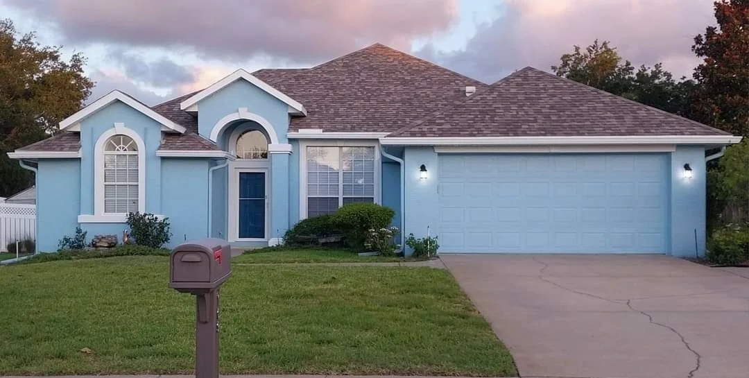 A professionally painted residential home- painted blue with white trim. 