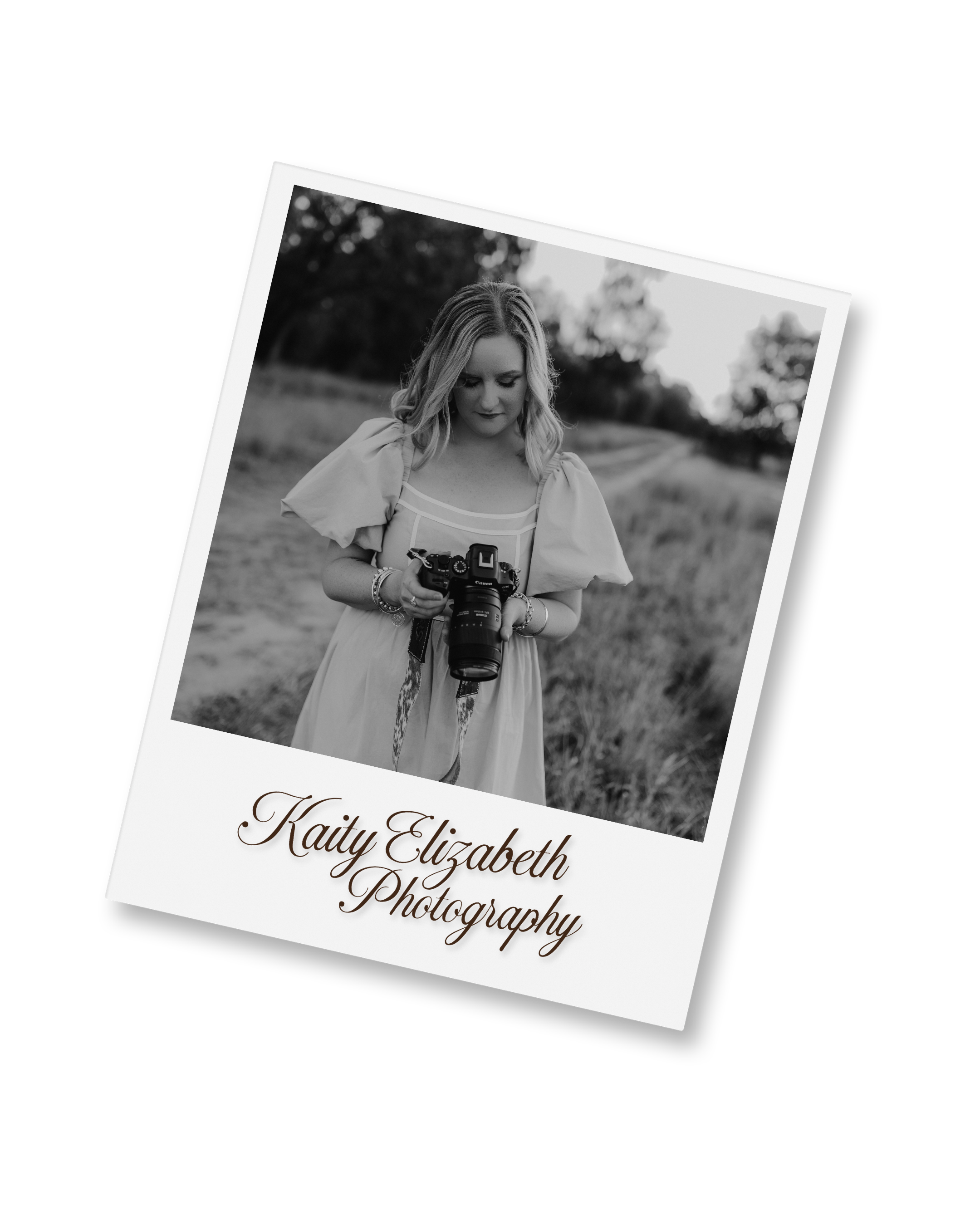 Black and white photo of a woman with long hair looking down at a camera she is holding, standing outdoors in a rural setting with trees and fields in the background, with the text 'Kaity Elizabeth Photography' below.