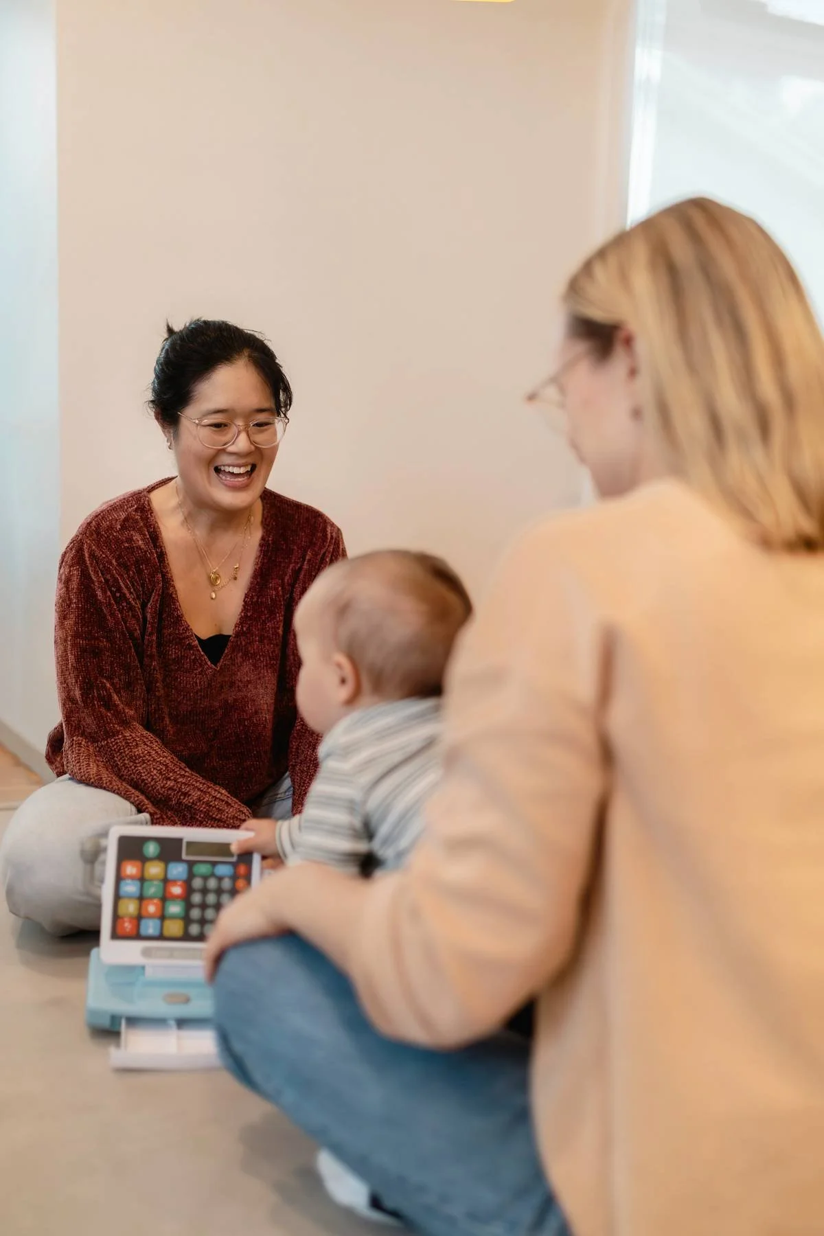 Occupational Therapist smiling with parent and baby with their backs to the camera