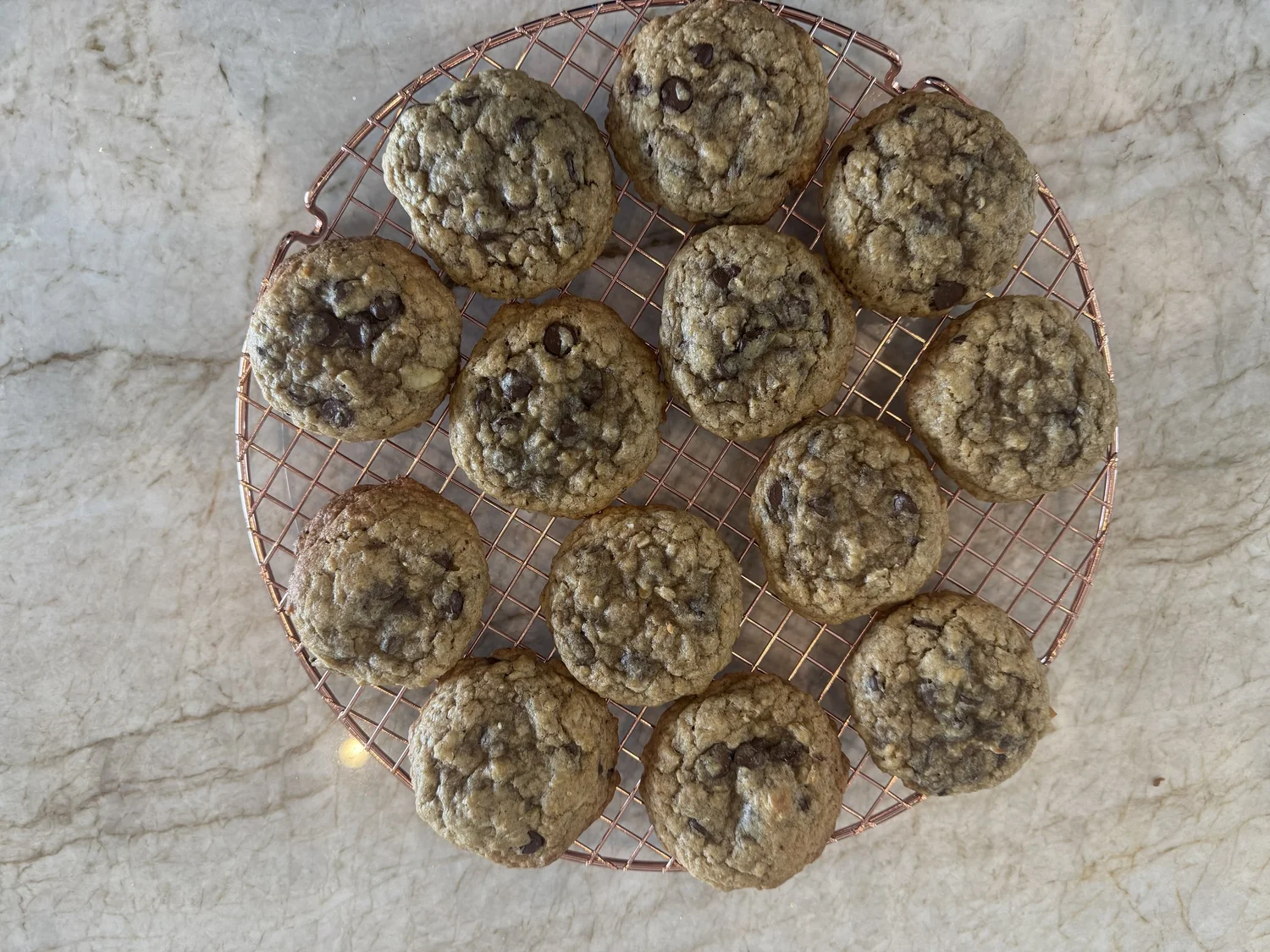 A dozen fresh-baked Murley cookies cooling on a copper rack
