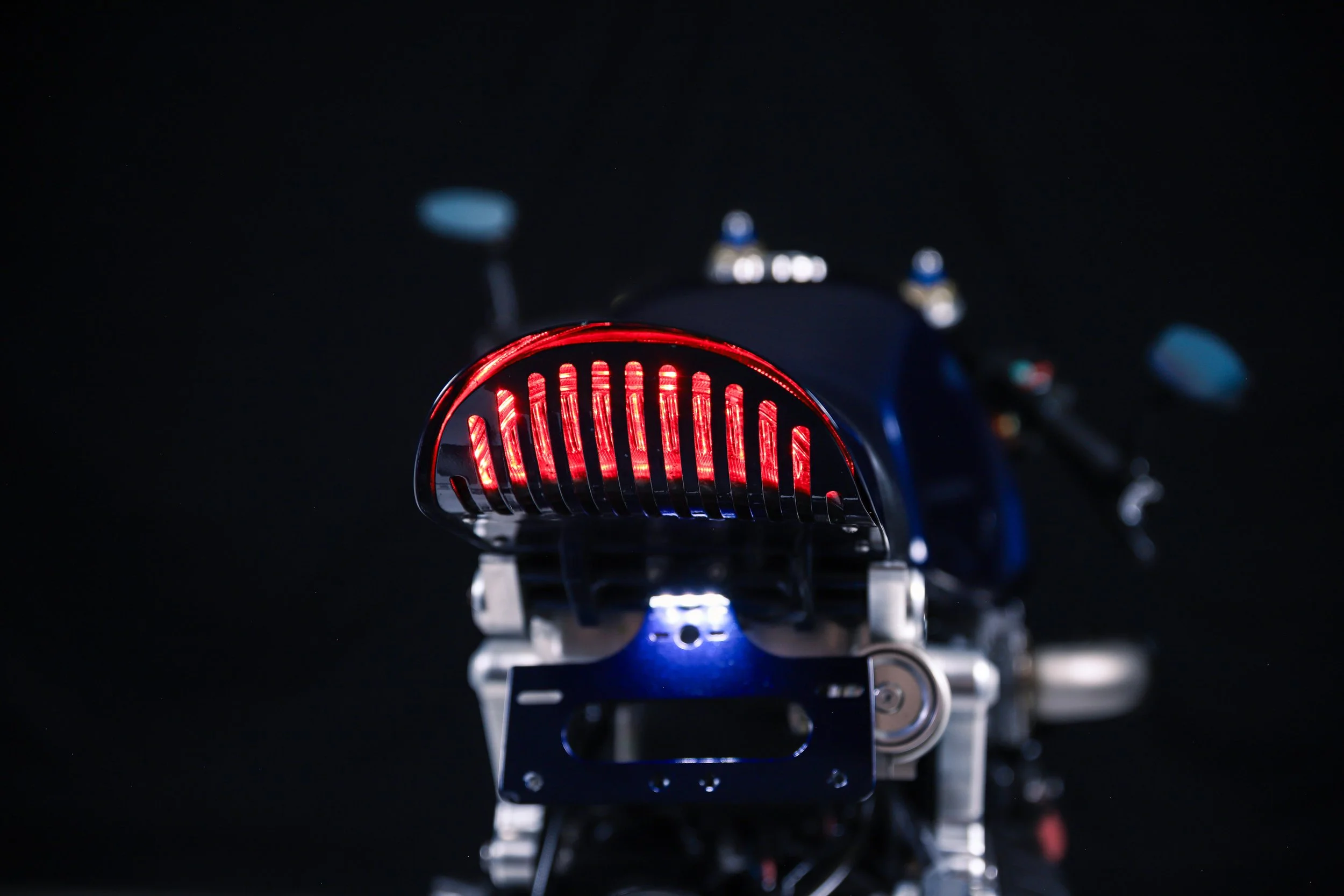 Close-up of a small robotic device or drone with red LED lights and a metallic structure, set against a dark background.