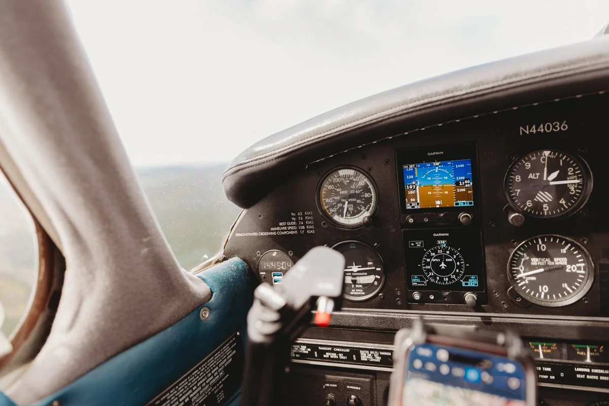 View of an airplane cockpit dashboard showing various gauges and digital instruments.