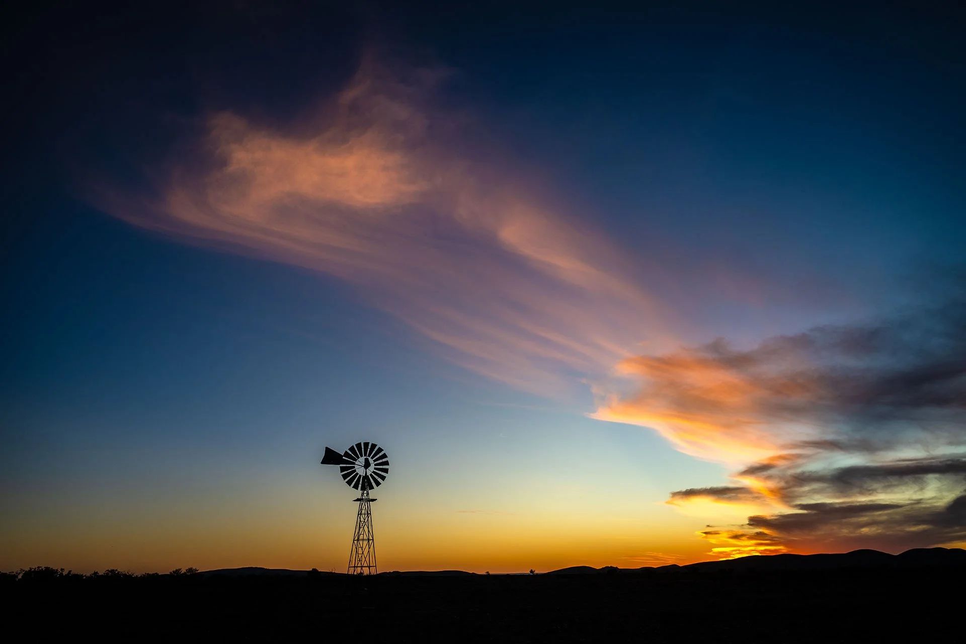 Windmill silhouette with cloud formations at sunset