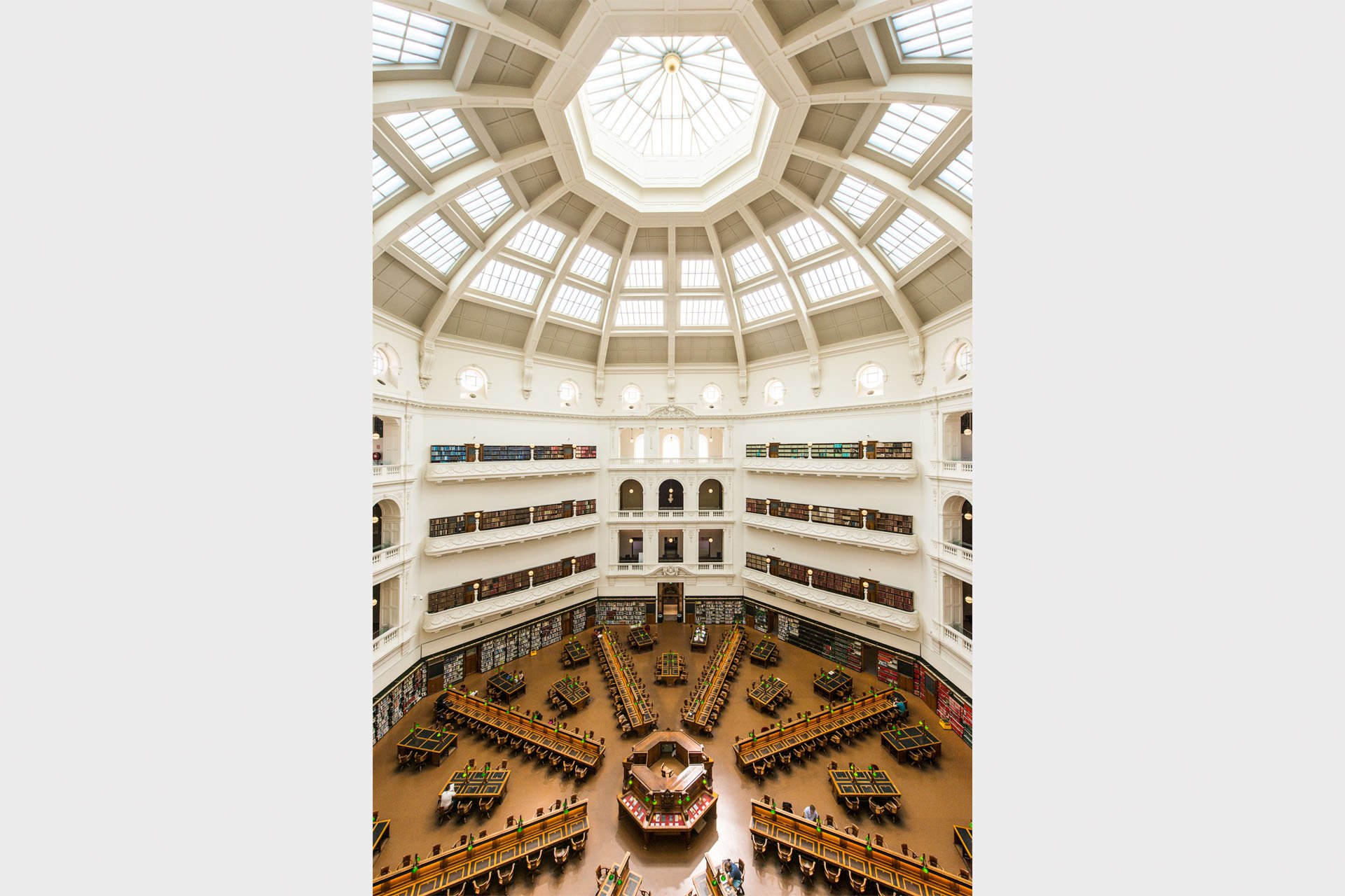 The domed La Trobe Reading Room at State Library Victoria, Melbourne, seen from above, with tiered book-lined galleries and reading desks radiating out beneath the octagonal skylight.