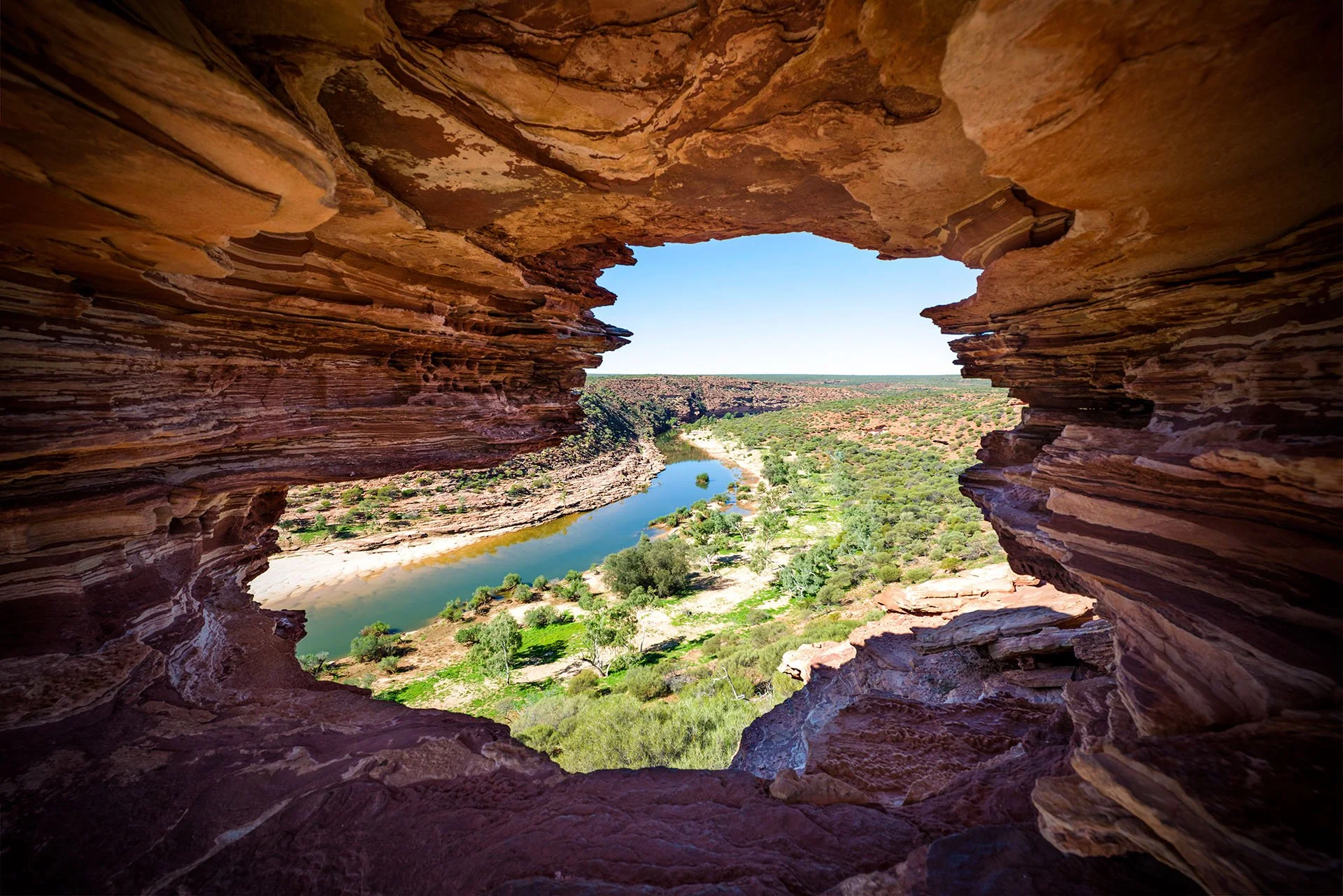 View through Nature’s Window, a natural sandstone rock arch framing the Murchison River gorge in Kalbarri National Park, Western Australia.