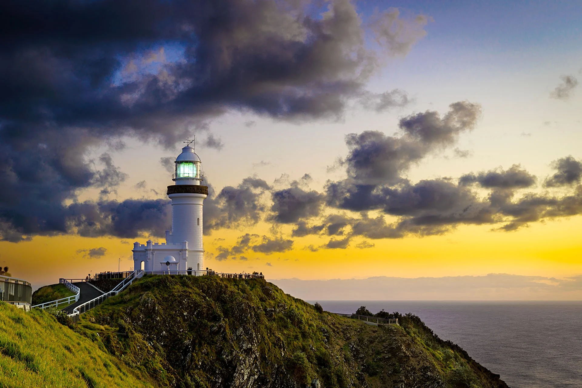 Lighthouse at sunset with a few storm clouds