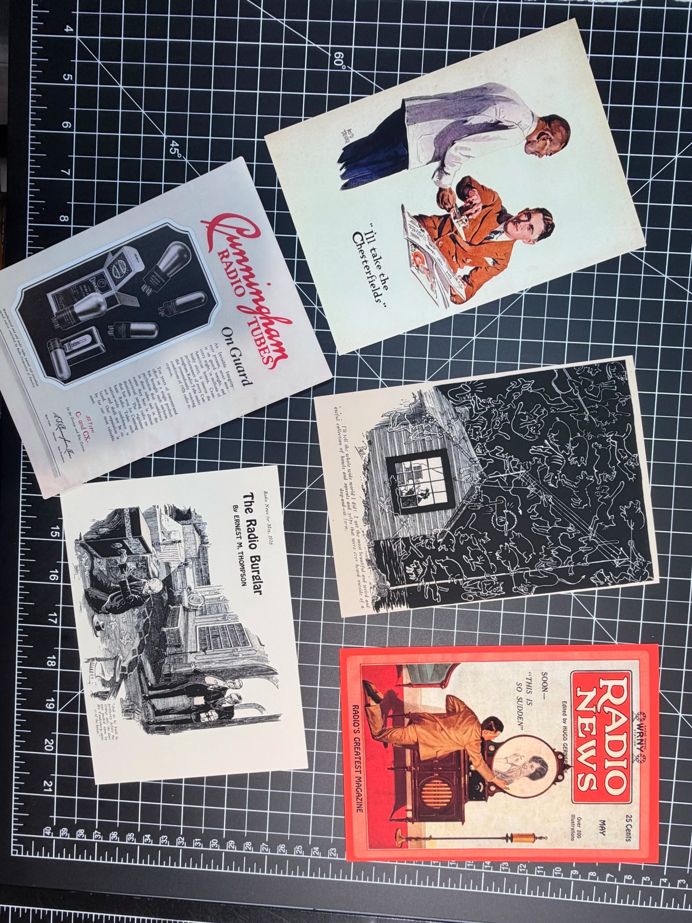 A curated collection of vintage 1920s ephemera for Vault & Vellum, including a Radio News cover, Cunningham Radio Tubes ad, and comic panels laid out on a black grid cutting mat.