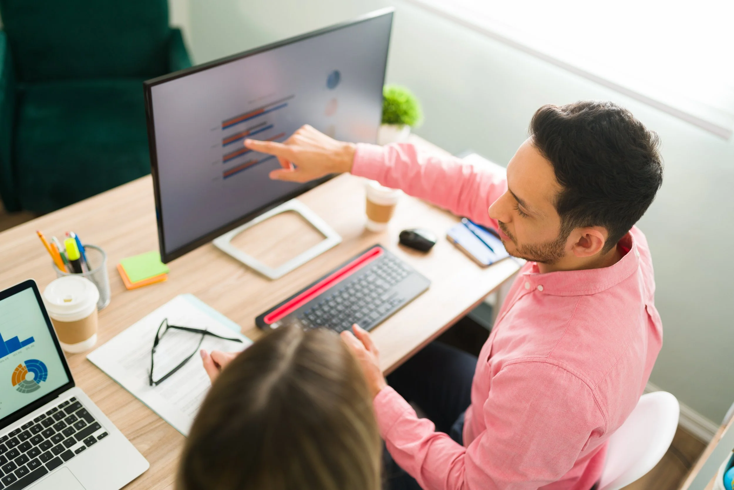attractive-man-pointing-computer-screen-business-presentation-while-sitting-office-professional-coworkers-working-analytical-report.jpg