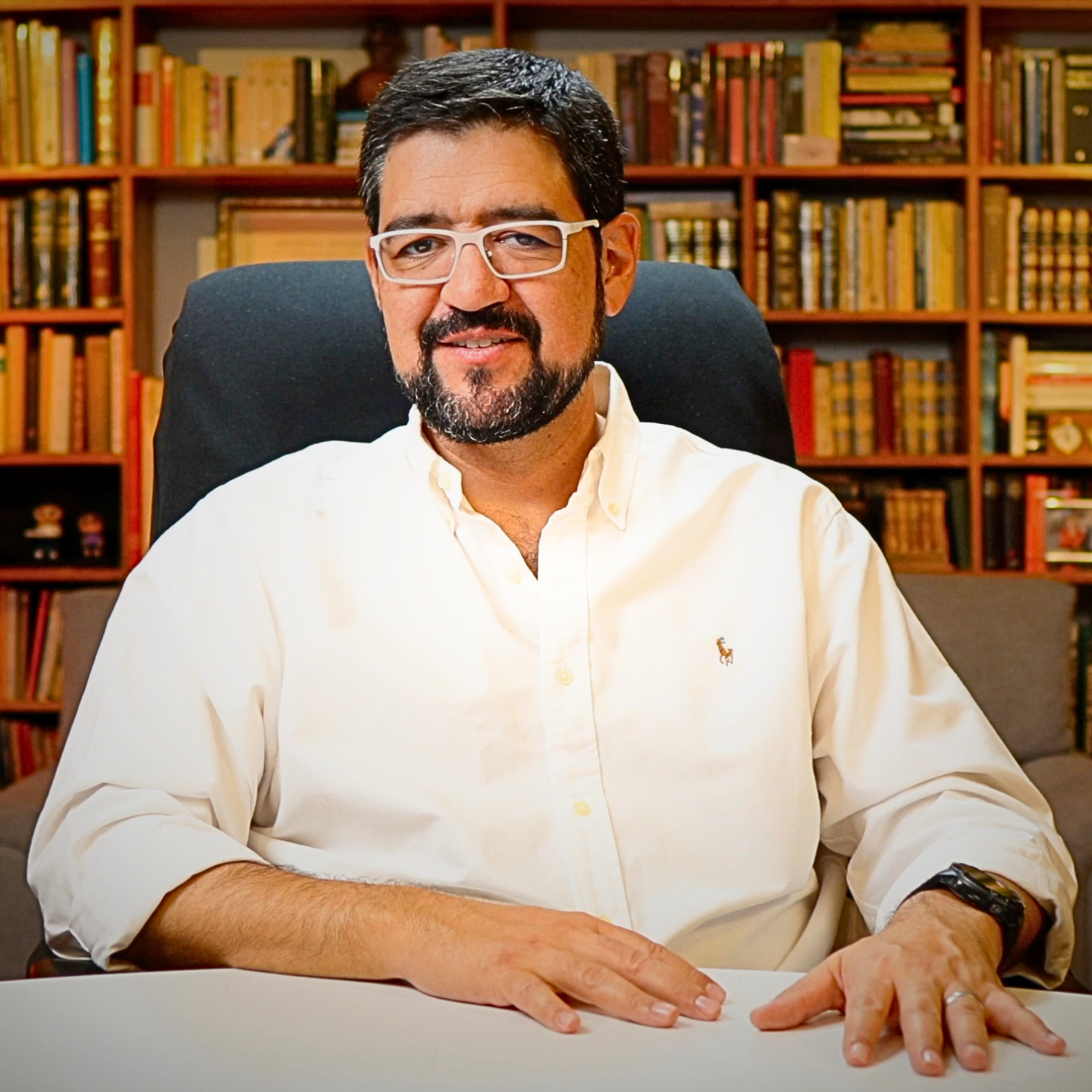 Roberto Duque Roquero en su estudio, director del Instituto Duque, con biblioteca al fondo.