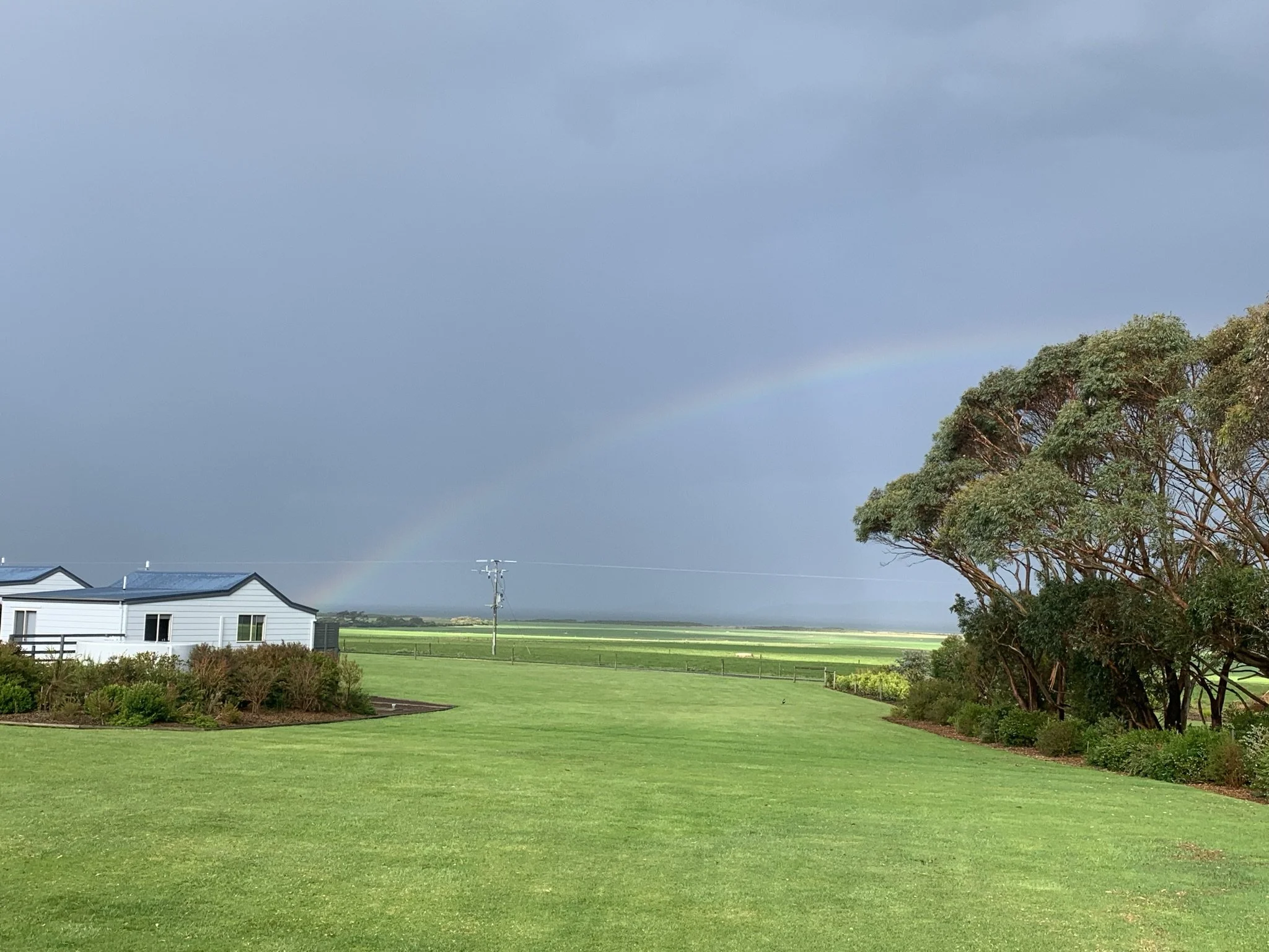 Rainbow over cabins and lawn at Prom Gate Getaway near Wilsons Prom