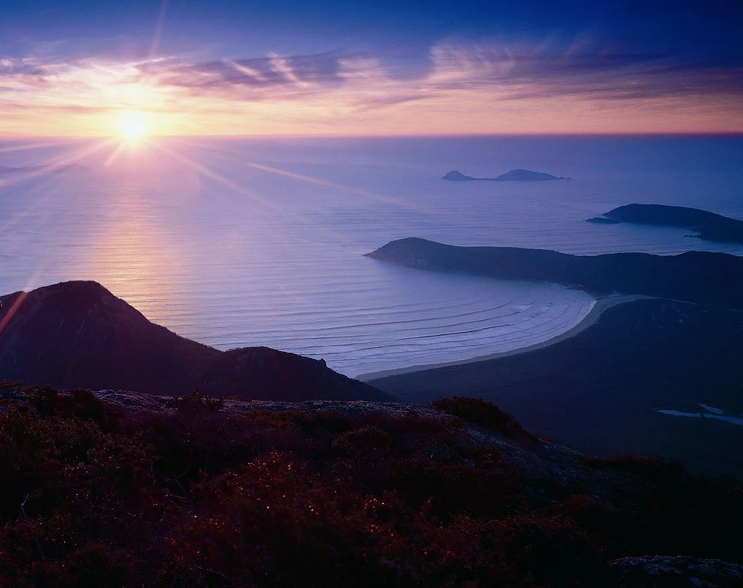 Sunrise over Wilsons Prom coastline with islands and rolling waves