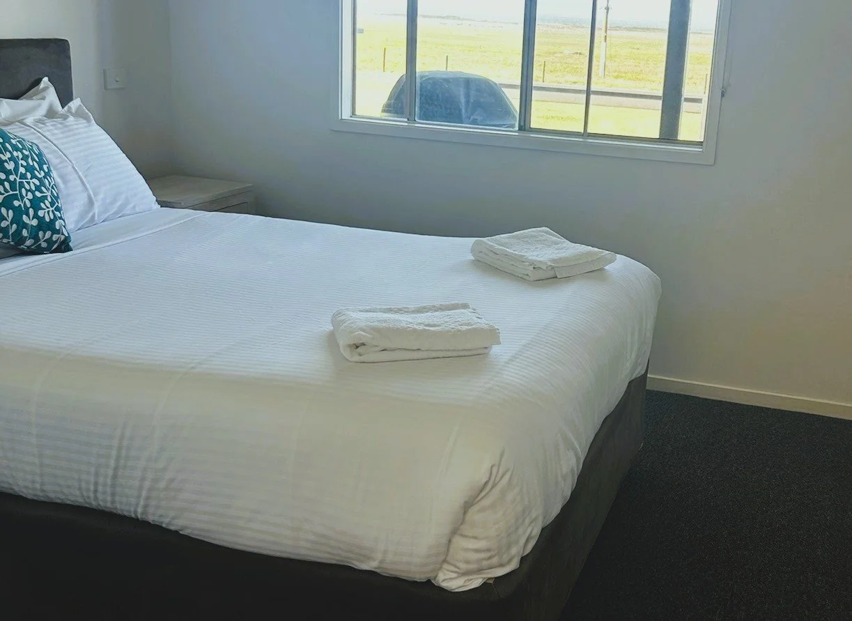 Bedroom with queen bed and fresh linens inside Prom Gate Getaway cabin