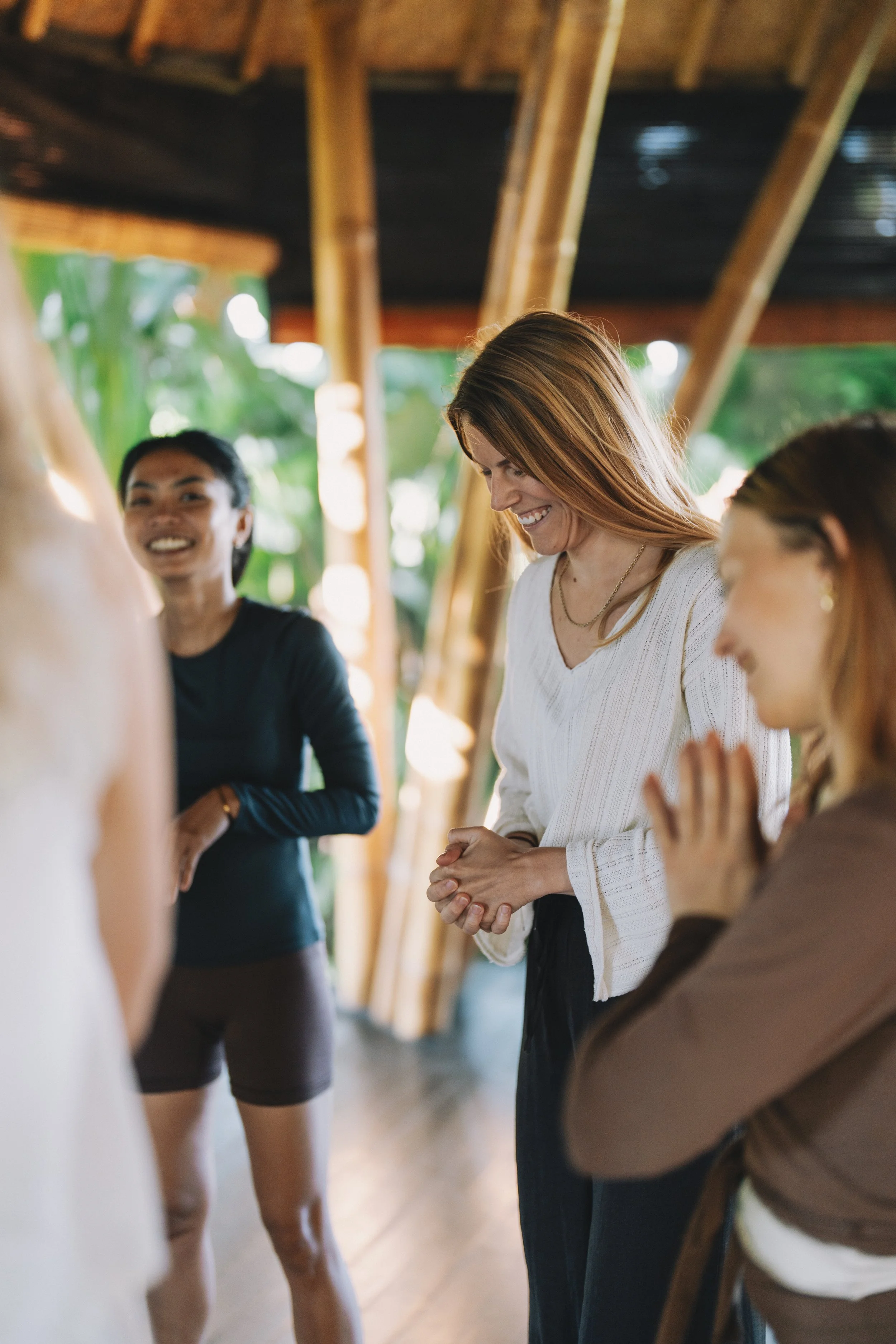 AYAMA Events - Menschen in einer Gruppe praktizieren gemeinsam in einem Holzhaus mit viel natürlichem Licht und grüner Natur im Hintergrund. Meditation und Nervensystemregulation in Rapperswil bei AYAMA.