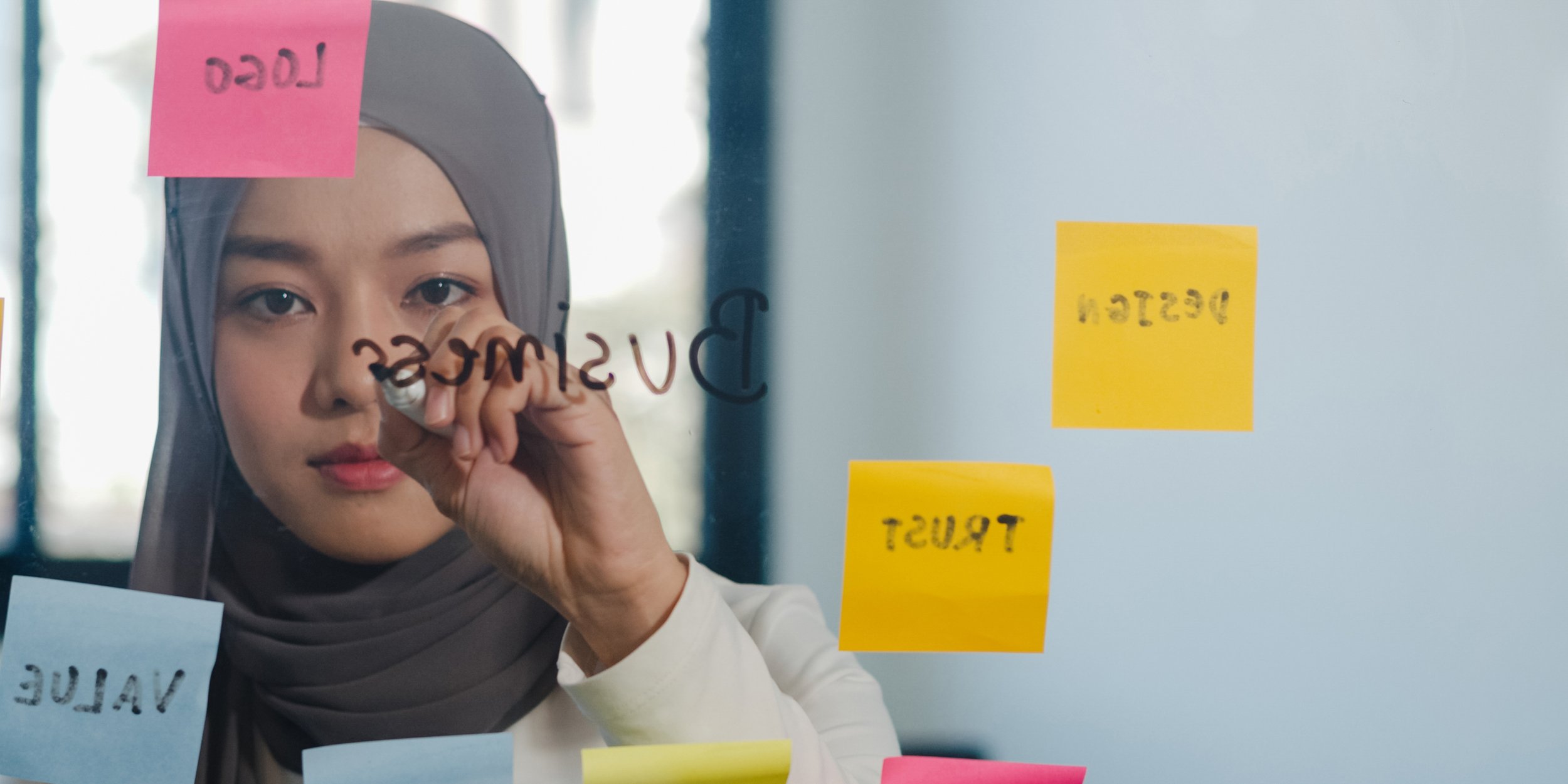 asian-muslim-lady-write-information-strategy-reminder-glass-board-new-normal-office.jpg
