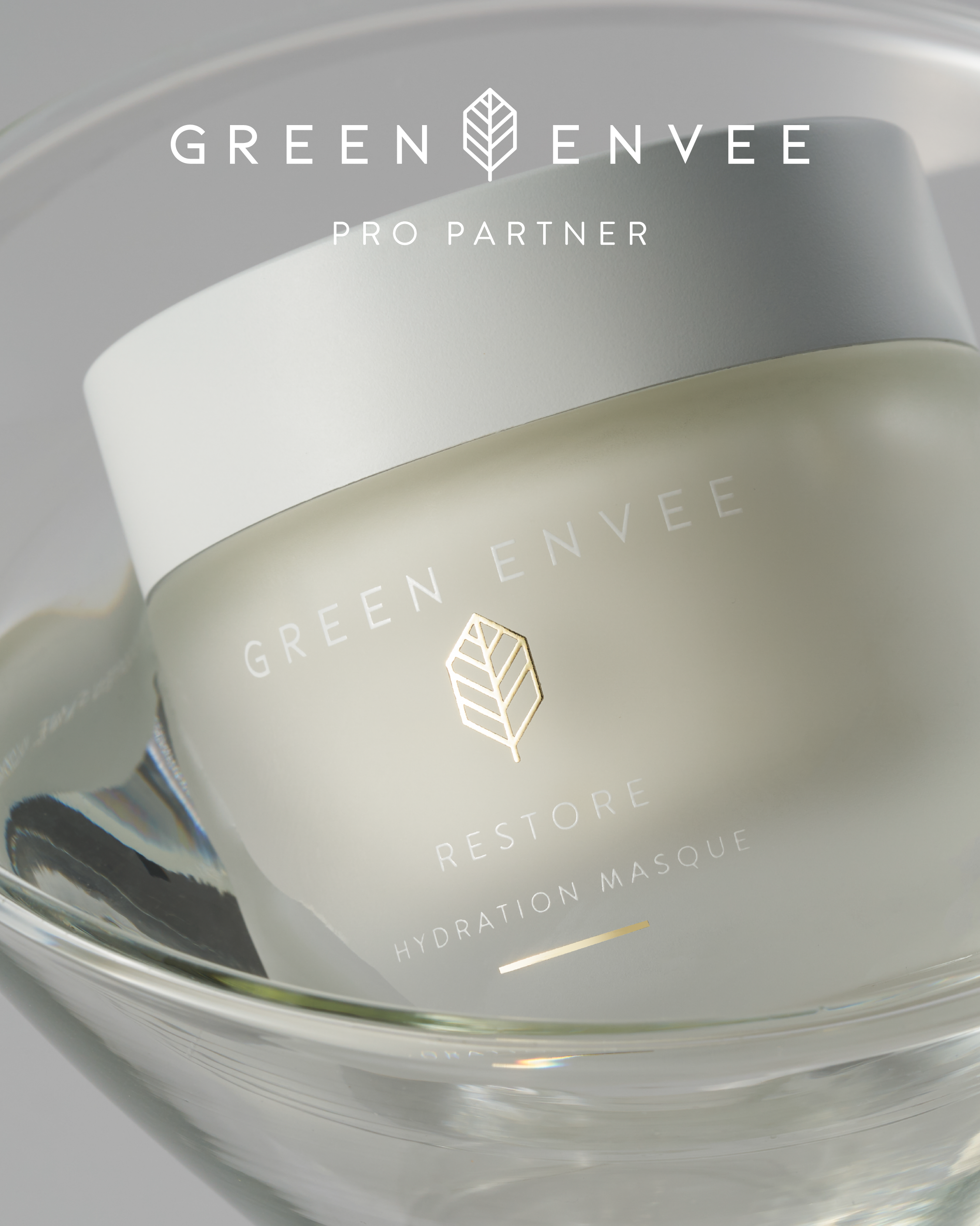 Close-up of a skincare product container with the label 'Green Envee Pro Partner' and a geometric leaf logo, emphasizing hydration and renewal. Toronto natural and botanical skincare line.
