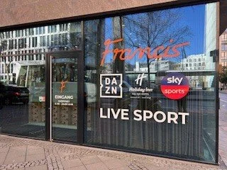  storefront with signs for DAZN, Sky Sports, and Live Sport. Entry to Francis Sports Bar and Restuarant which is Frankfurt's favourite sportsbar.