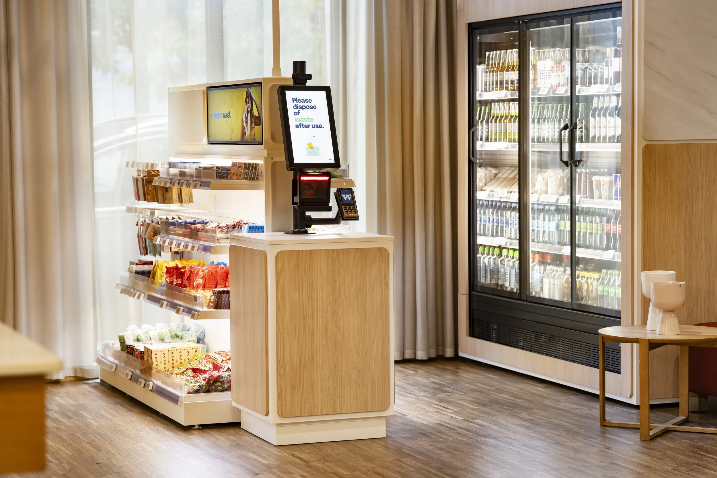 Inside a convenience store with a snack display and refrigerated drinks