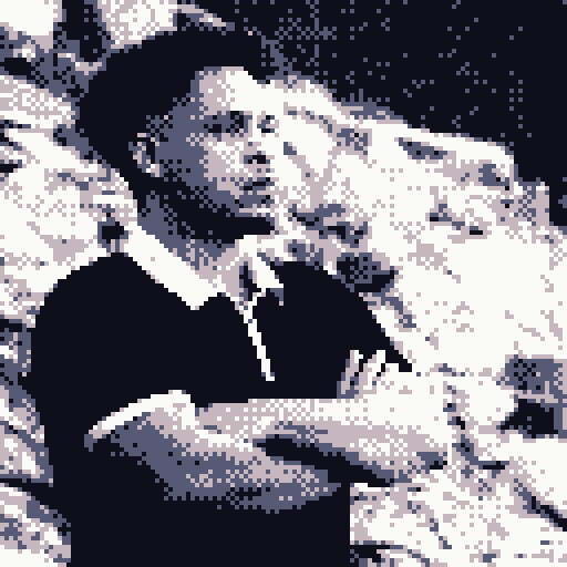 A pixelated black and white photo of a young man standing outdoors. He's wearing a dark shirt with white accents on the collar and a watch on his left wrist, with arms crossed. The background shows rocks or a similar textured surface.