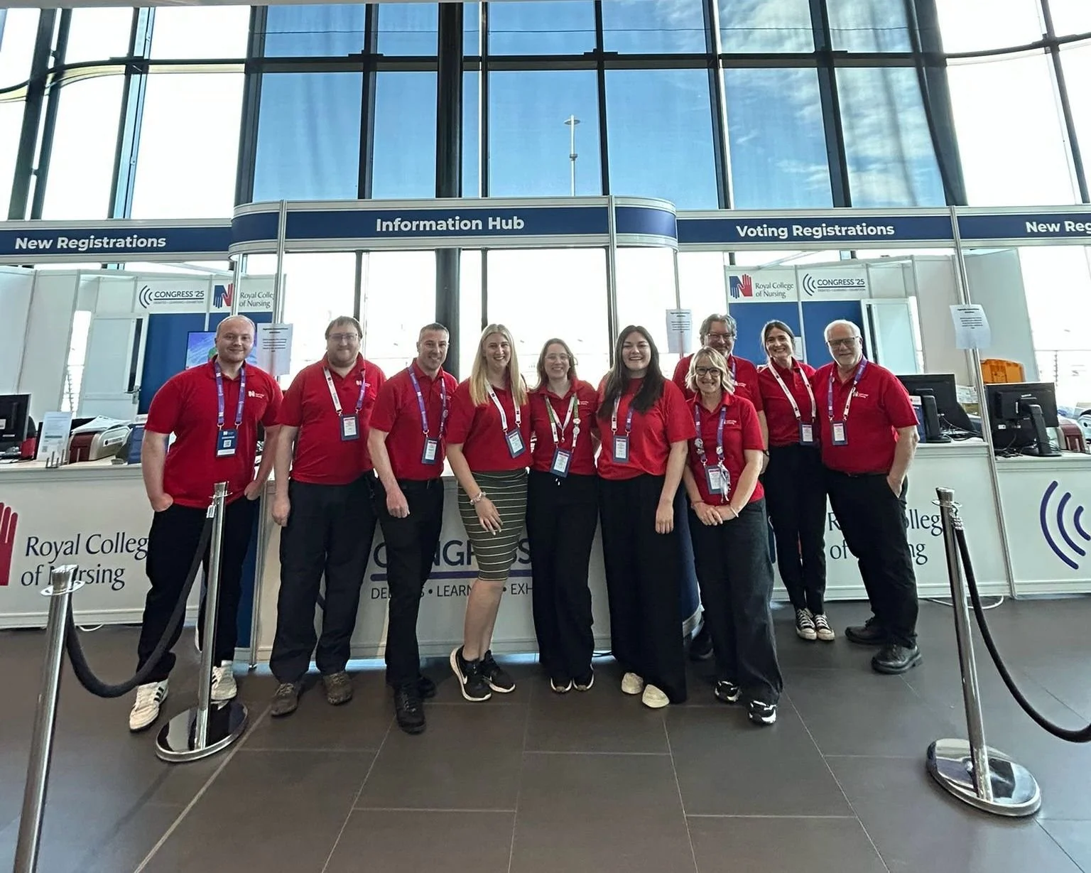 Group of people wearing red shirts at the Royal College of Nursing Congress information desk.