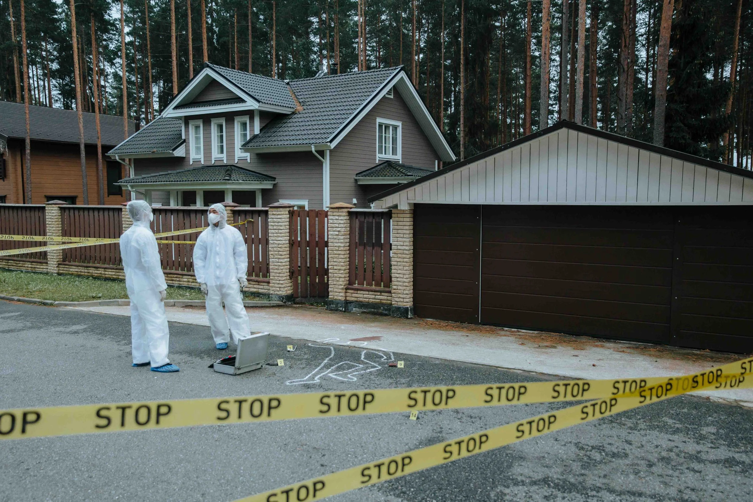 two men in personal protective clothing, waiting to go an clean a crime scene